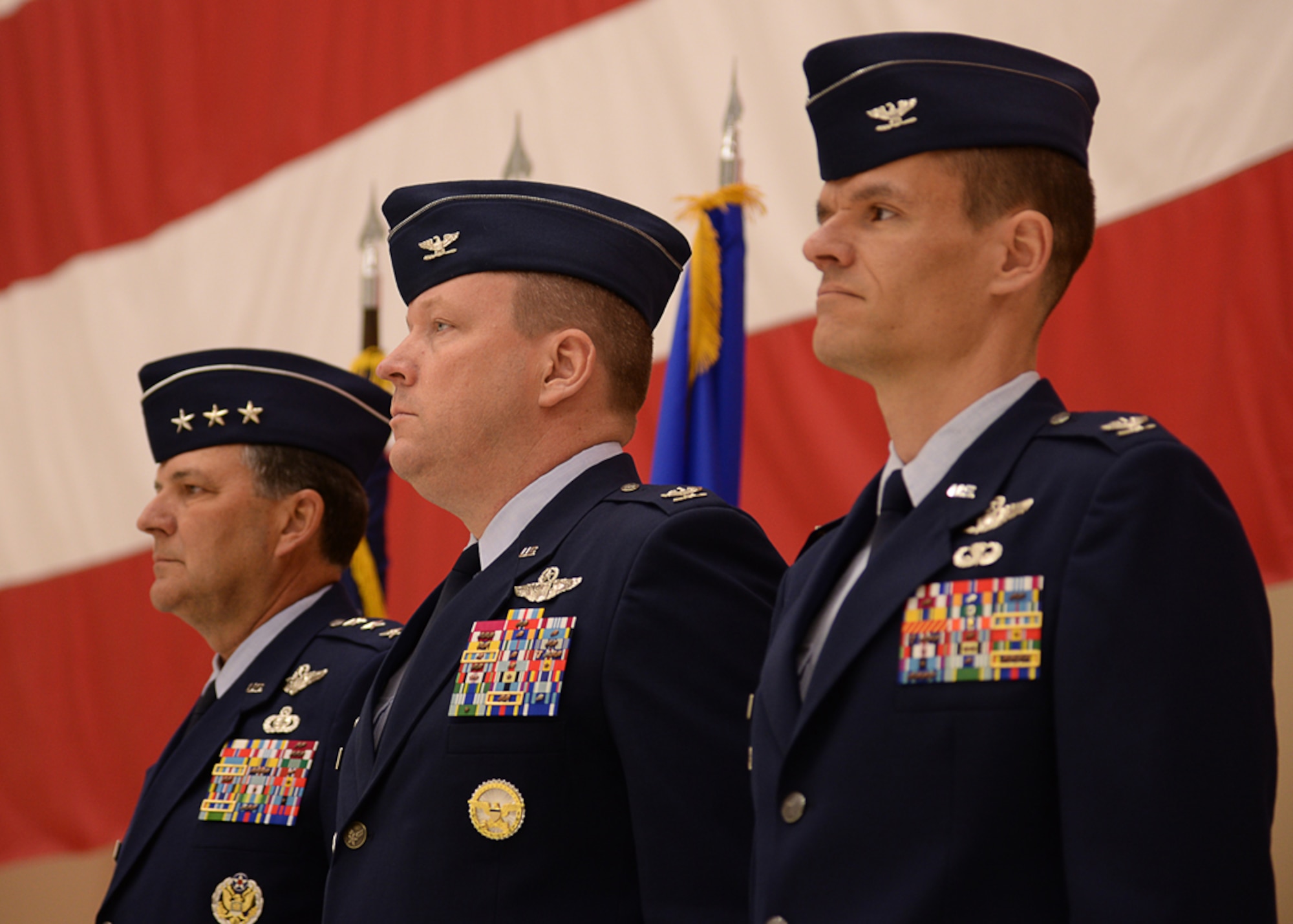 U.S. Air Force Lt. Gen. Bradley Heithold, Commander Air Force Special Operations Command, Col. Tony Bauernfeind, outgoing 27th Special Operations Wing commander, and Col. Benjamin Maitre, incoming 27th SOW commander, stand at attention before the National Anthem singing during the 27th SOW change of command ceremony, Feb. 17, 2015 at Cannon Air Force Base, N.M.  The change of command represents the closure of one chapter and the beginning of another for Air Commandos of the 27th SOW.  (U.S. Air Force photo/Airman 1st Class Chip Slack)