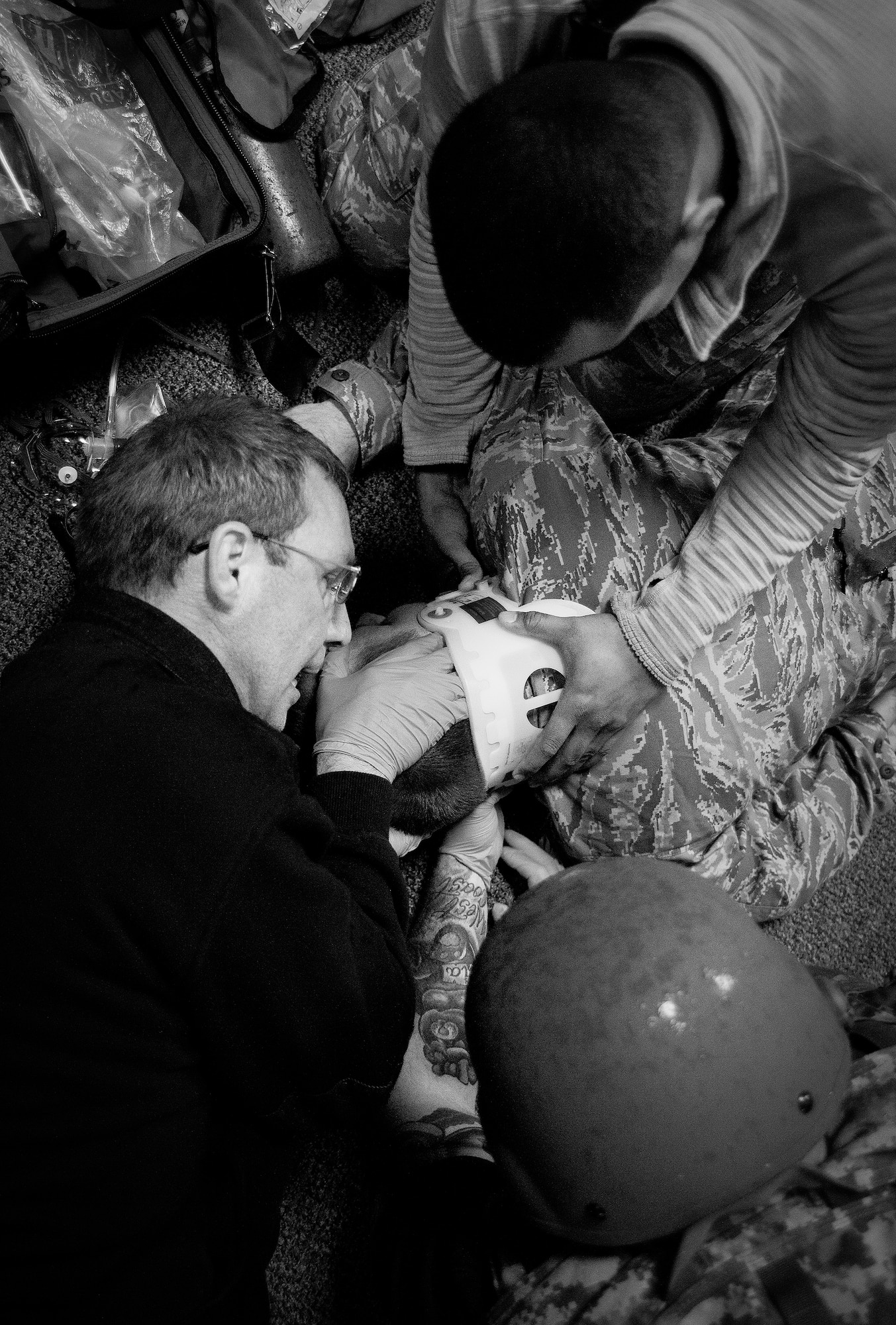 Medical technicians and firefighters move a simulated gunshot victim with a spinal injury onto a gurney during an active shooter exercise Feb. 4 at Duke Field, Fla.  Upon the all clear notification from security forces, the first responders entered the building to take care of the wounded victims. (U.S. Air Force photo/Samuel King Jr.)