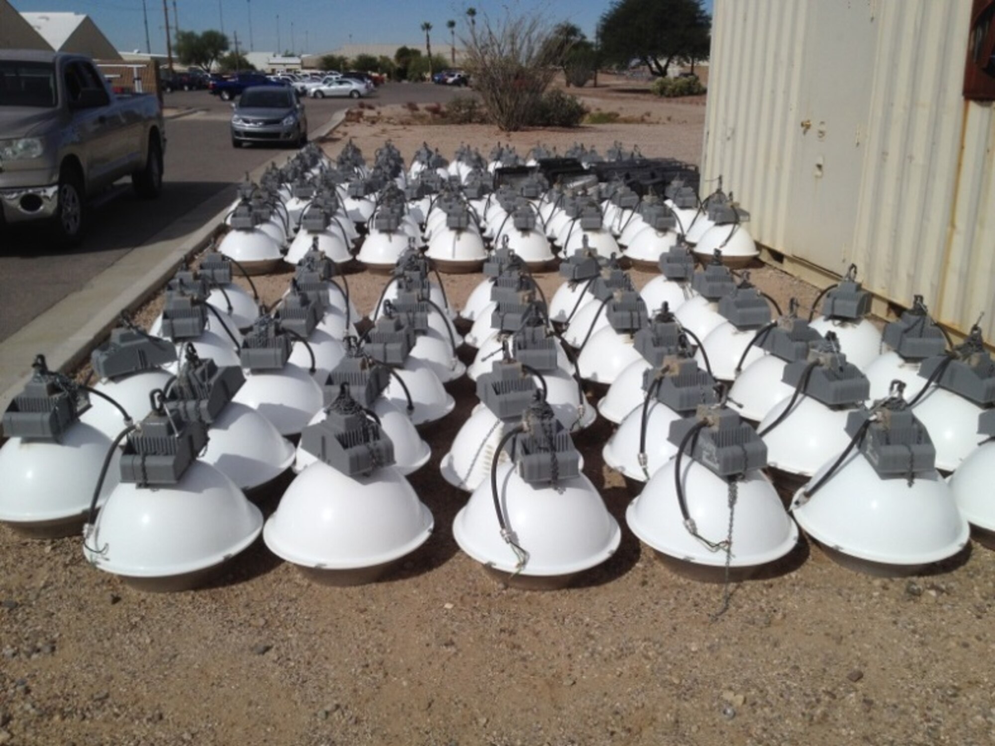 High pressure sodium lighting fixtures lie arranged on the ground at Davis-Monthan Air Force Base, Ariz. T5HO fluorescent lights replaced 675 high pressure sodium lighting fixtures as a result of energy efficiency lighting upgrades. D-M's energy efficiency programs were able to save the installation a total of $235K during fiscal year 2013, successfully exceeding the federal energy goals. (Courtesy photo)