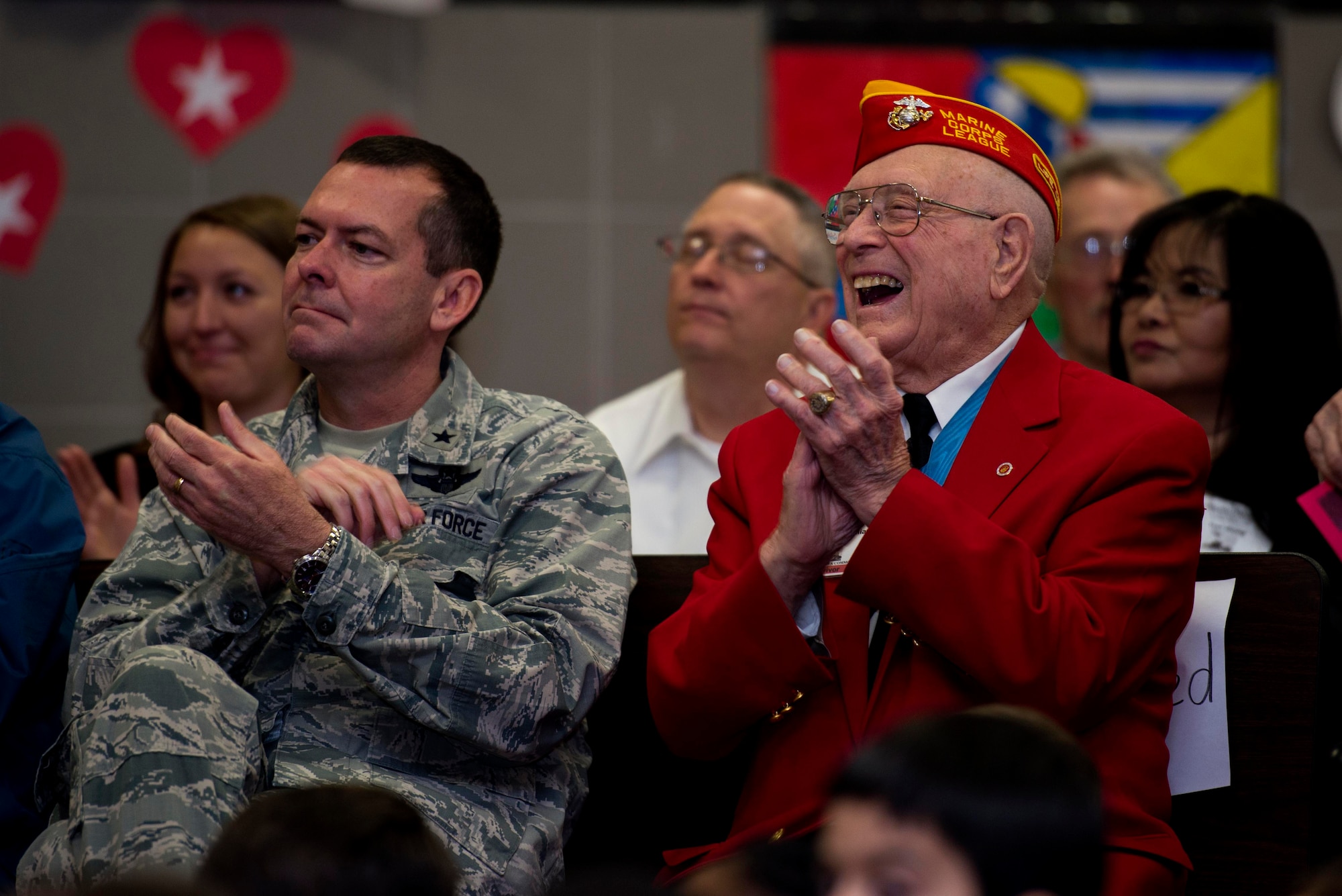 U.S. Air Force Brig. Gen. Scott Kindsvater, 82nd Training Wing commander, sits beside Hershal “Woody” Williams, Iwo Jima survivor and Medal of Honor recipient, during the Iwo Jima Survivors 70th Reunion at Sheppard Air Force Base, Texas, Feb. 13, 2015. Kindsvater and Williams applaud for the Sheppard Elementary School students after they delivered their speeches. This will be the last reunion of the Iwo Jima survivors. (U.S. Air Force photo by Senior Airman Kyle Gese/Released)