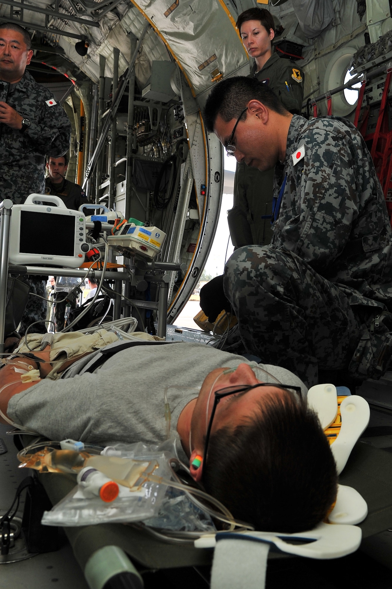 Japan Air Self-Defense Force Master Sgt. Kazuyuki Kinoshita, emergency medical technician, evaluates an aeromedical evacuation patient at Sinapalo, Rota, Feb. 16, 2015, prior to takeoff. Exercise COPE NORTH 15 enhances humanitarian assistance and disaster relief crisis response capabilities between six nations and lays the foundation for regional cooperation expansion during real-world contingencies in the Asia-Pacific Region. (U.S. Air force photo by Staff Sgt. Melissa B. White/Released)