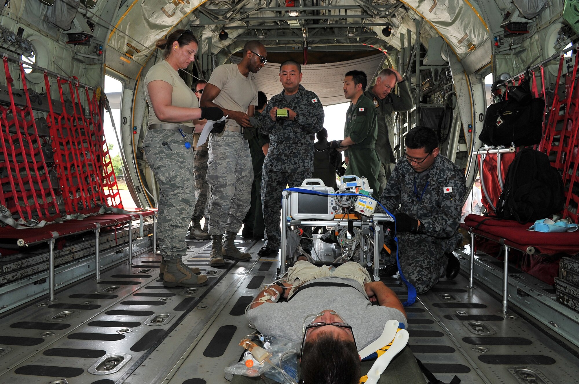 U.S. Air Force Airmen transfer a critical care patient to a Japan Air Self-Defense Force aeromedical evacuation team at Sinapalo, Rota, Feb. 16, 2015. Exercise COPE NORTH 15 enhances humanitarian assistance and disaster relief crisis response capabilities between six nations and lays the foundation for regional cooperation expansion during real-world contingencies in the Asia-Pacific Region. (U.S. Air Force photo by Staff Sgt. Melissa B. White/Released)