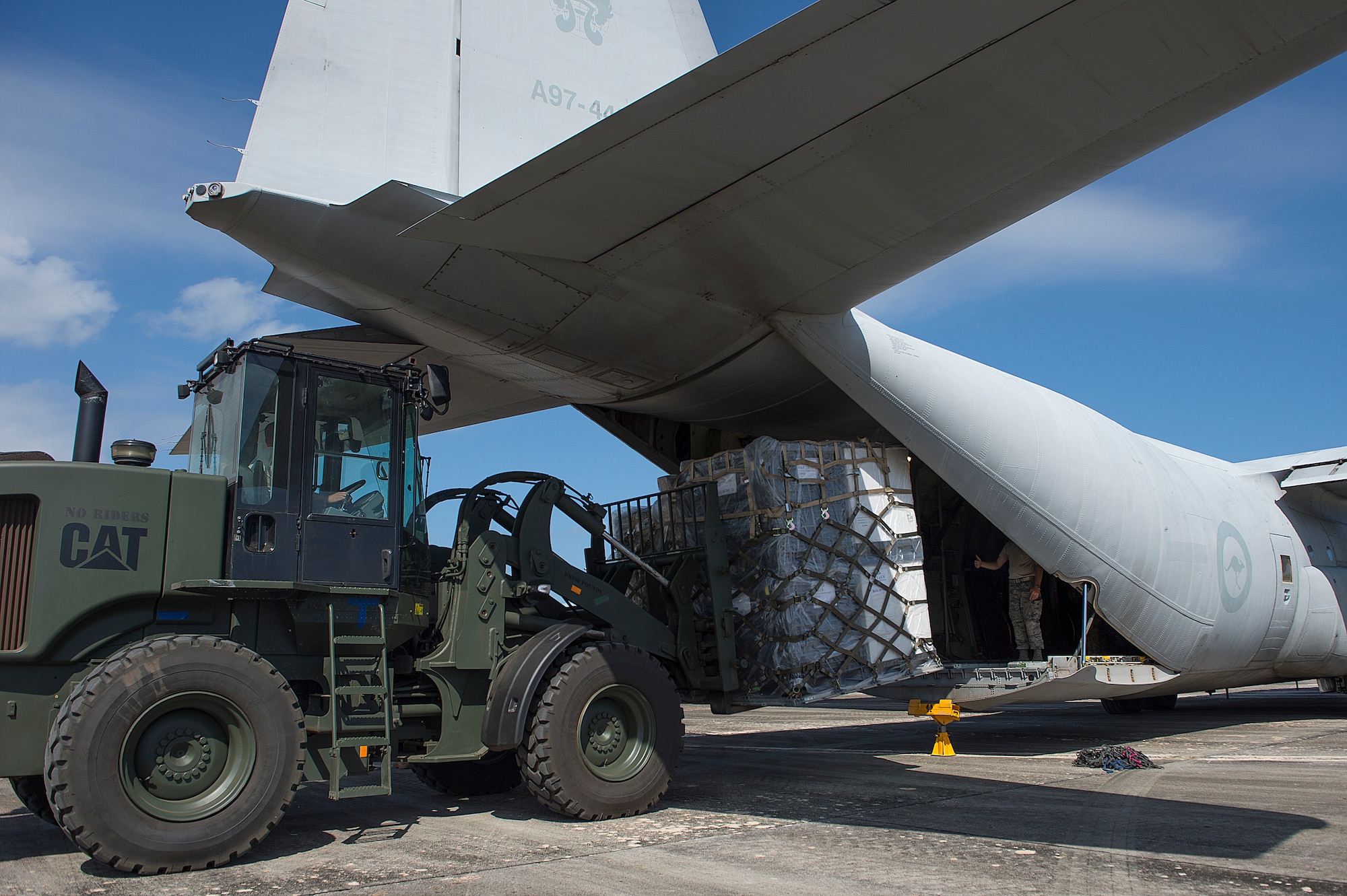U.S. Air Force Airmen from the 36th Contingency Response Group offload cargo from a Royal Australian Air Force C-130 Hercules during a humanitarian assistance and disaster relief training event at exercise COPE NORTH 15 at Rota, Northern Mariana Islands, Feb. 15, 2015. Exercise CN 15 enhances humanitarian assistance and disaster relief crisis response capabilities between six nations and lays the foundation for regional cooperation expansion during real-world contingencies in the Asia-Pacific Region. (U.S. Air Force photo by Tech. Sgt. Jason Robertson/Released)