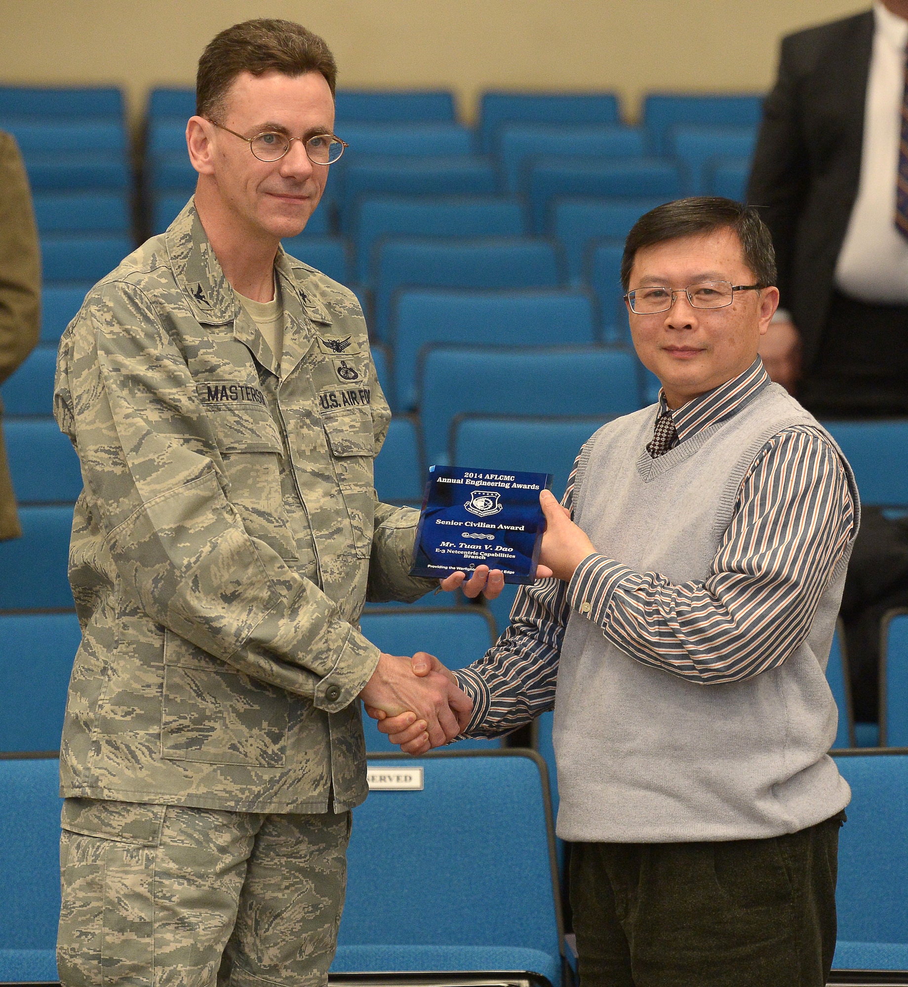 Col. Edward Masterson, deputy associate director of Engineering and Technical Management, presents the 2014 Air Force Life Cycle Management Center Engineering Senior Civilian Engineering Award to Tuan Dao, Airborne Warning and Control System lead engineer, during an awards ceremony at the Hanscom Conference Center, Feb. 12. Dao competed against other senior civilian engineers across AFLCMC. (U.S. Air Force photo by Jerry Saslav)
