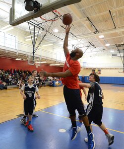 Devon Burroughs, a Hanscom Middle School special education tutor, shoots the ball over students during a student versus faculty basketball game at the Hanscom Sports and Fitness Center Feb. 13. The student team won the game 41 to 36. (U.S. Air Force photo by Jerry Saslav)