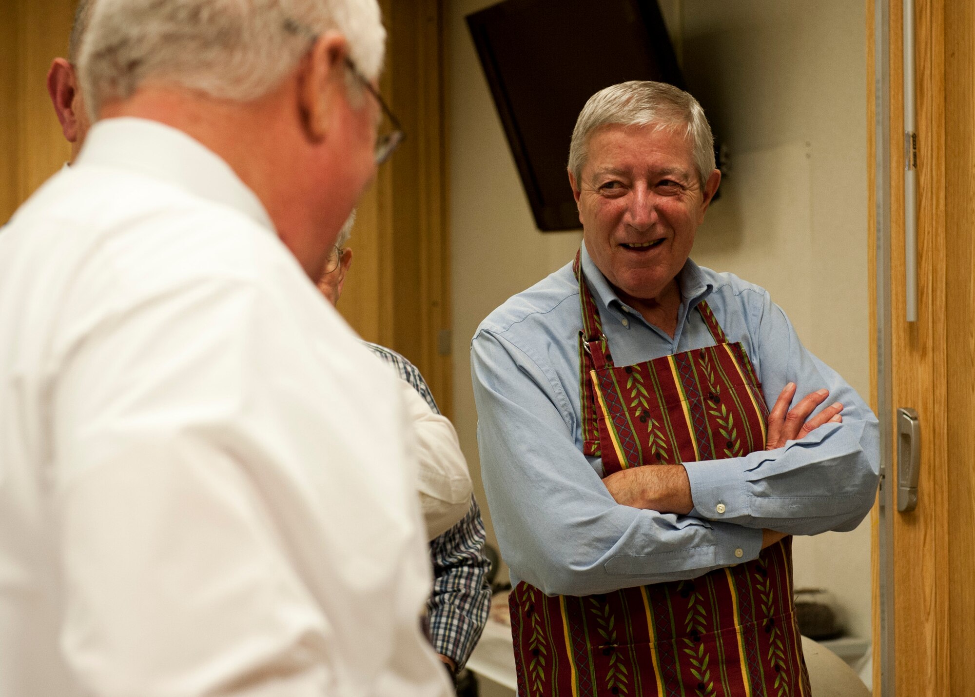 PETERSON AIR FORCE BASE, Colo. - Father David Voelker, retired priest, chats with the other volunteers before the spaghetti dinner at the Chapel, Feb. 12, 2015. Voelker shares his sauce with members of Team Pete the second Thursday of each month with a free spaghetti dinner. (U.S. Air Force photo by Senior Airman Tiffany DeNault)