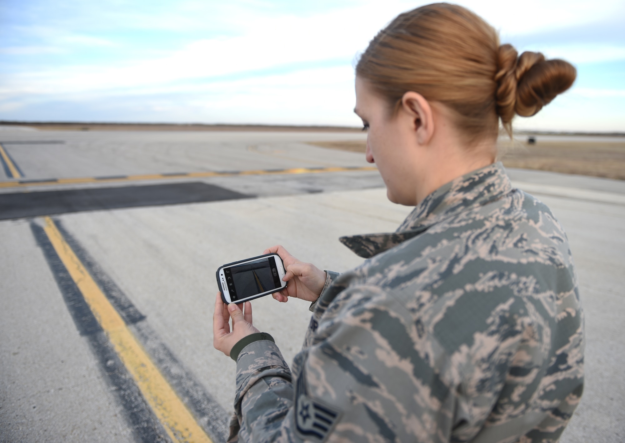 U.S. Air Force Staff Sgt. Amanda Bragg, 7th Operation Support Squadron airfield management operations supervisor, uses an the Airfield Manager app to document repaired section of runway Feb. 3, 2015, at Dyess Air Force Base, Texas.  The app was designed by U.S. Air Force Master Sgt. Terrance Miller, 7th Operation Support Squadron airfield manager, to facilitate a more efficient way to track damages and repairs on flight lines. (U.S. Air Force photo by Airman 1st Class Alexander Guerrero/Released)