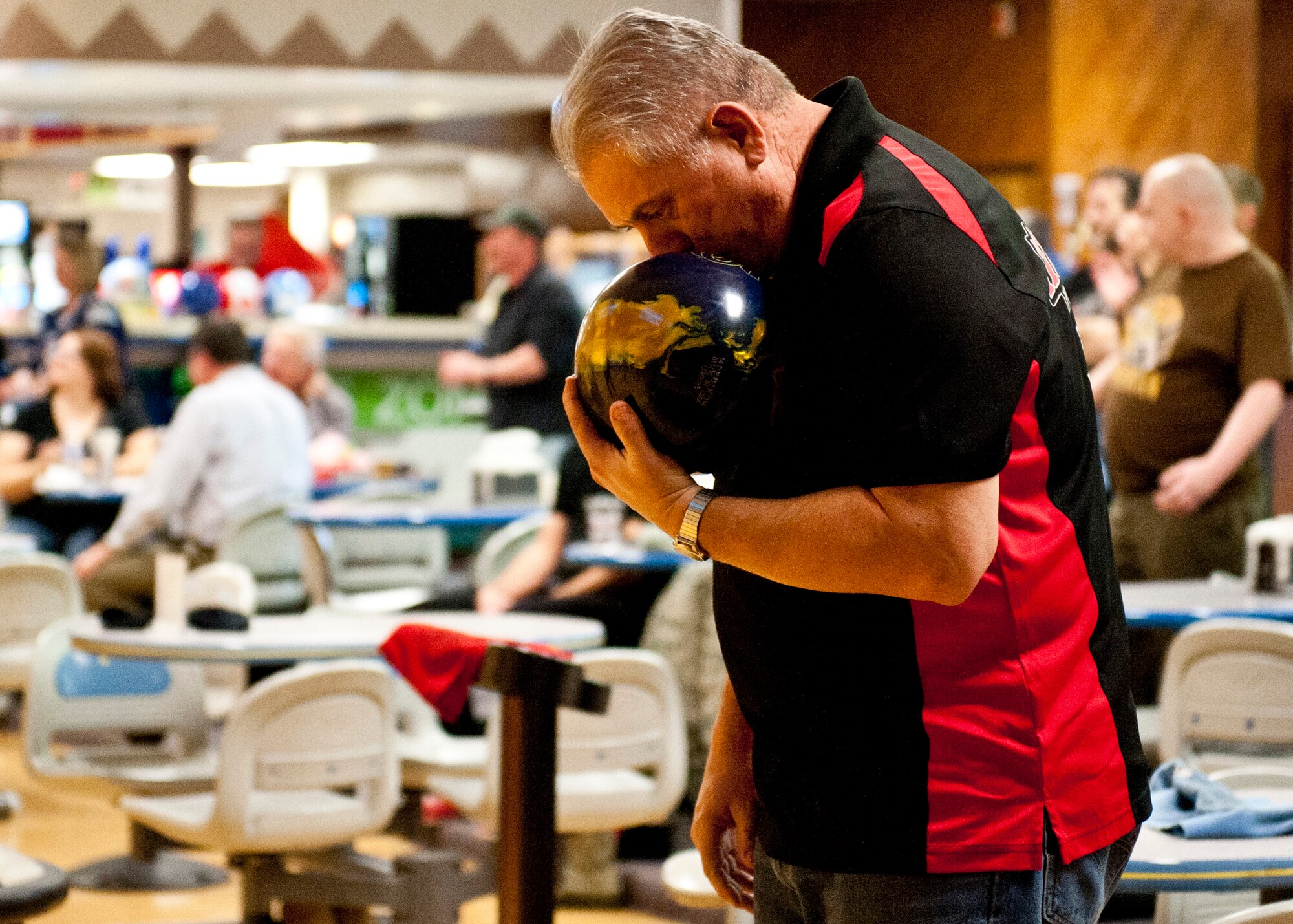 PETERSON AIR FORCE BASE, Colo. – Johnathon Karagiannes, member of the Magnificent Seven bowling league team, kisses his bowling ball before his turn during a bowling tournament at the Peterson Bowling Center, Feb. 5, 2015. The Magnificent Seven bowling league team has won twice in the league and is pursuing a third victory. Sixteen teams and approximately 150 bowlers participate in the intramural competitions twice a week. (U.S. Air Force photo by Senior Airman Tiffany DeNault)