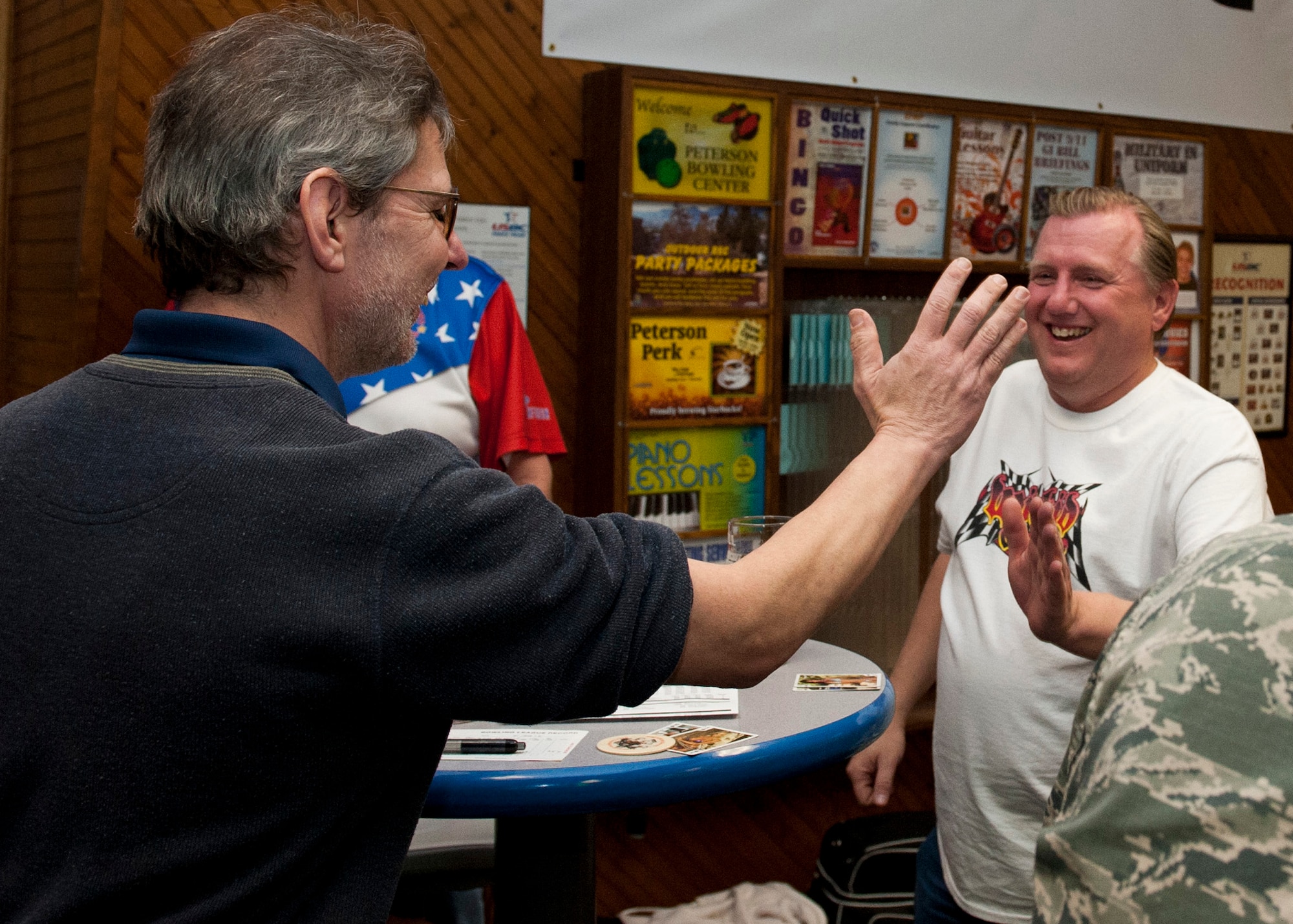 PETERSON AIR FORCE BASE, Colo. – Members of the Magnificent Seven bowling league team high five during a tournament at the Peterson Bowling Center, Feb. 5, 2015. The Magnificent Seven team won the intramural league twice and is pursuing a third victory. Sixteen teams and approximately 150 bowlers participate in the intramural competitions twice a week. (U.S. Air Force photo by Senior Airman Tiffany DeNault)