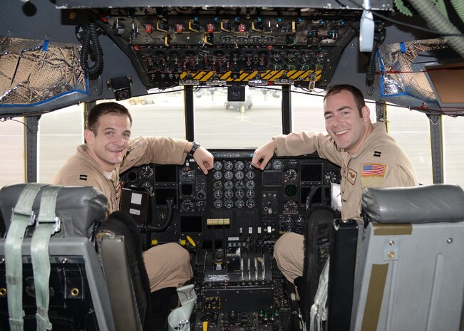 Capt. Andrew Metzger (left) and his brother Capt. Brian Metzger sit in the cockpit of a C-130H here Feb. 7, 2015. Andrew is a C-17 pilot stationed at Joint Base Charleston, S.C., and Brian is an Air Force Reserve C-130 Hercules pilot deployed from Dobbins Air Reserve Base, Ga. (U.S. Air Force photo by 1st Lt. Sarah Ruckriegle)