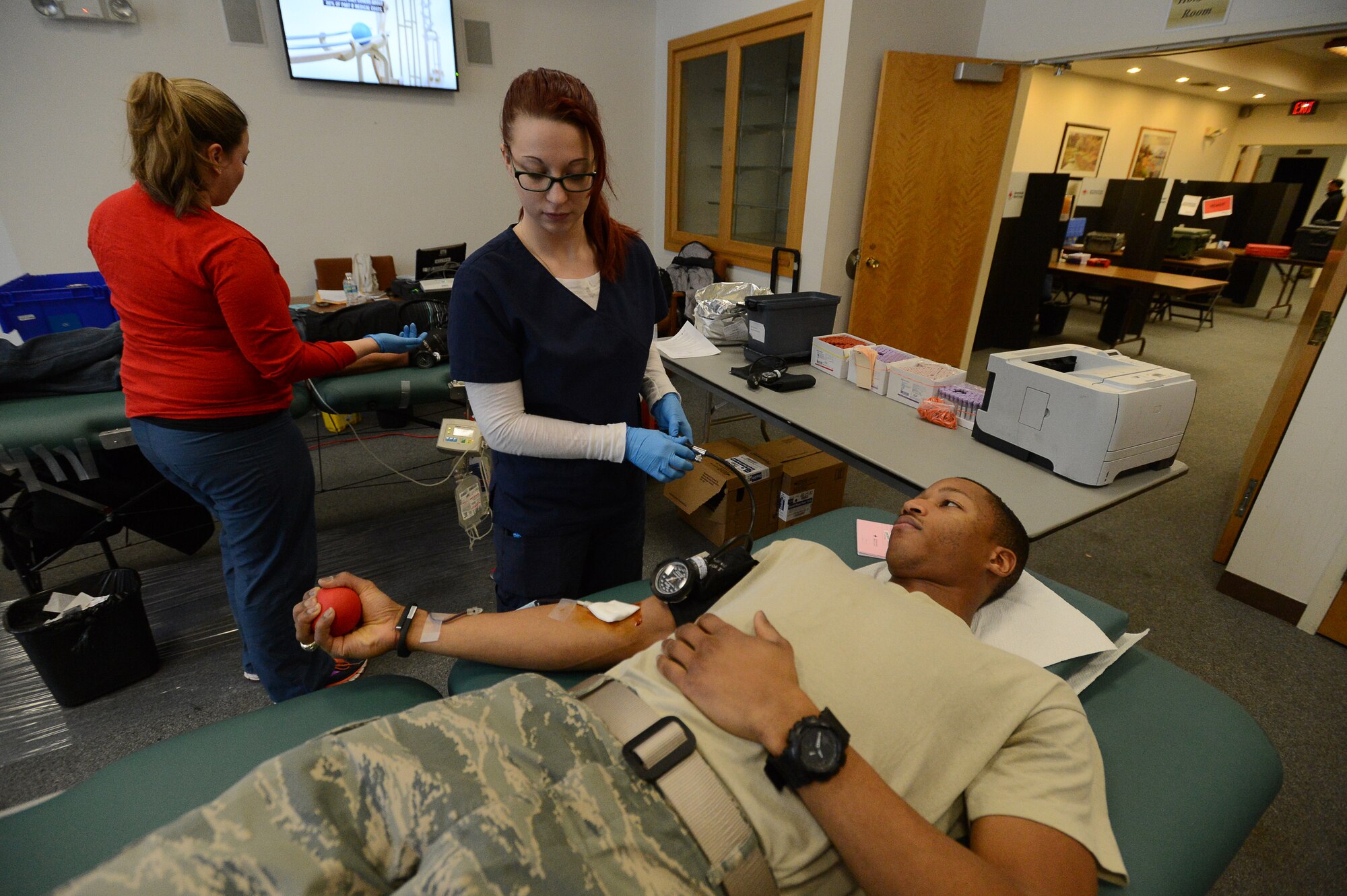 Brandi Haggstrom, American Red Cross phlebotomist, releases the air from a blood pressure cuff on the arm of Capt. William Swinton, C3I Infrastructure Division program manager, during a blood donation drive at the Hanscom Conference Center, Feb. 17. The base collects more than 100 units during a usual two-day blood drive on base. For more information on donating blood through the Red Cross, visit http://www.redcross.org/blood. (U.S. Air Force photo by Jerry Saslav)
