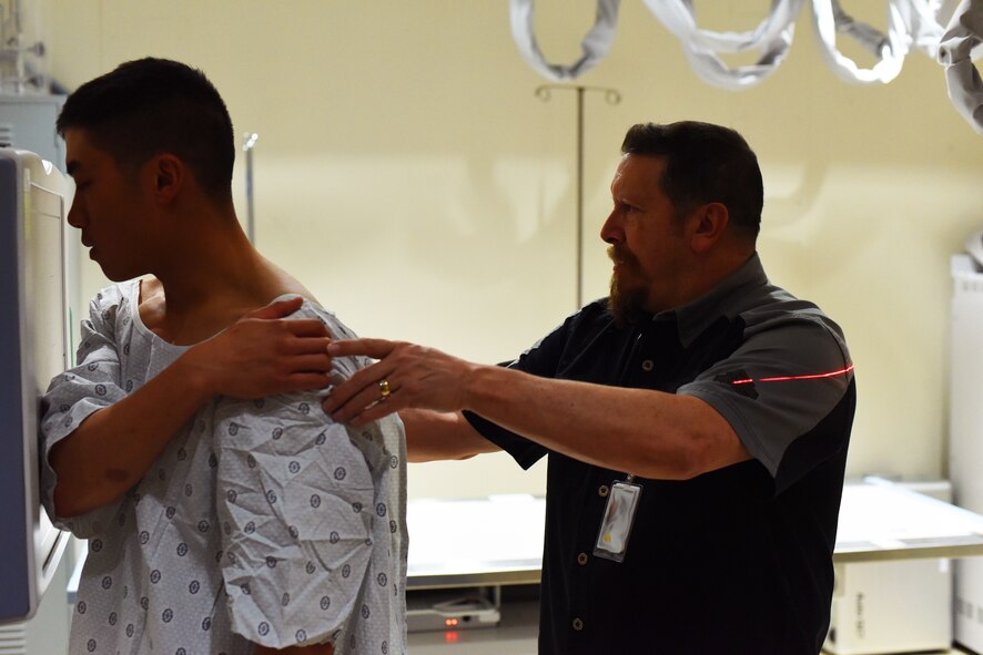 1st Lt. Lance Wu, 741st Missile Security Forces Squadron tactical response force flight commander (left), follows instructions from Lee Weideman, 341st Medical Support Squadron radiology technician, as he is positioned for an X-ray at Malmstrom Air Force Base’s radiology clinic Feb 12. Last year alone, Malmstrom’s clinic provided diagnostic imaging for 3,000 patients. (U.S. Air Force photo/Airman 1st Class Collin Schmidt)