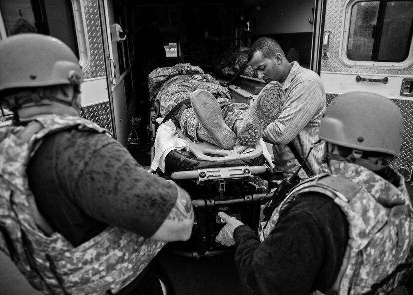 Medical technicians and firefighters move a simulated gunshot victim with a spinal injury onto an ambulance during an active shooter exercise Feb. 4 at Duke Field, Fla.  Upon the all clear notification from security forces, the first responders entered the building to take care of the wounded victims. (U.S. Air Force photo/Samuel King Jr.)