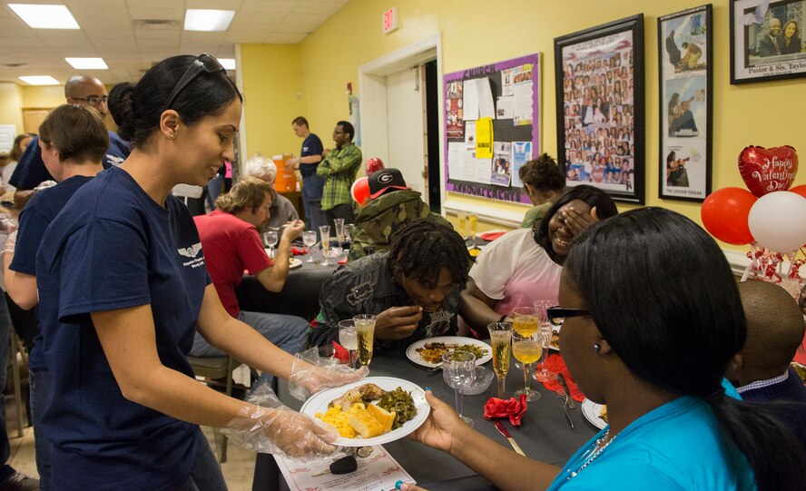 U.S. Air Force Master Sgt. Sandra Medina, AFSA communications trustee, serves a guest during the Third Annual Valentine’s Day Banquet Feb. 12, 2015, in Valdosta, Ga. The banquet consisted of dinner, entertainment, giveaways and fellowship for homeless and low-income families in the local community. (U.S. Air Force photo by Airman 1st Class Ceaira Tinsley/Released)