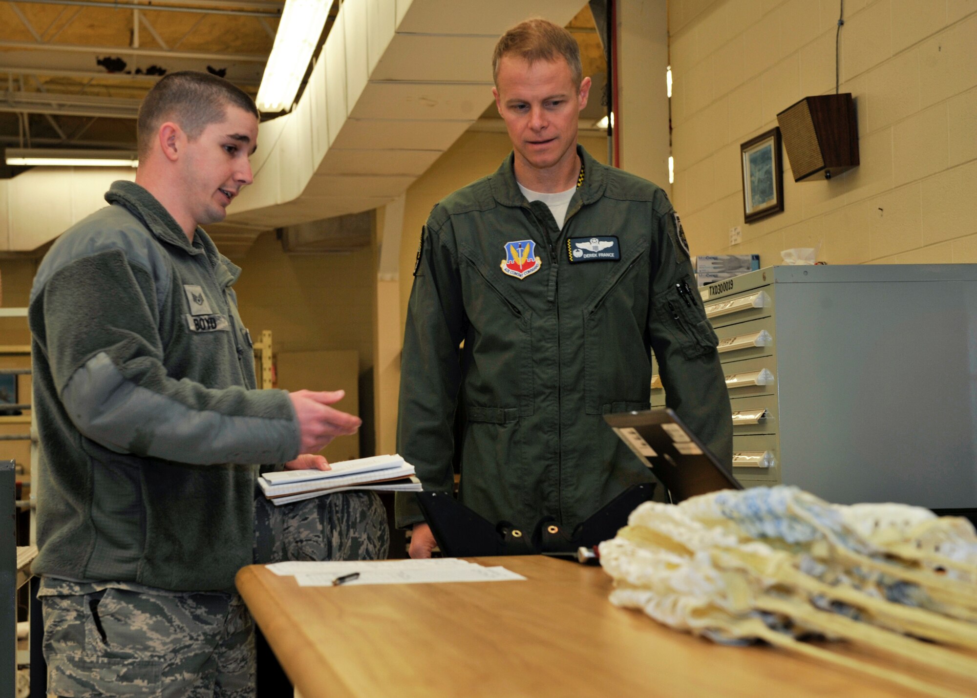 Staff Sgt. Phillip Boyd, 325th Operation Support Squadron aircrew flight equipment quality assurance evaluator, explains to Col. Derek C. France, 325th Fighter Wing commander, what he does during his job on Feb. 13. France followed Boyd as part of the Airman Shadow Program. (U.S. Air Force photo by Airman 1st Class Sergio A. Gamboa/Released)