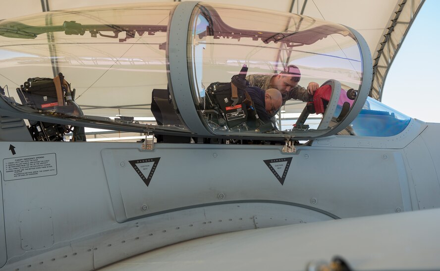 U.S. Air Force Senior Airman Joseph Bagnasco, 23d Civil Engineer Squadron driver operator, receives instruction from Wayne Krieter, Sierra Nevada Corporation aircraft inspector, during A-29 Super Tucano egress training Feb. 12, 2015, at Moody Air Force Base, Ga. The training is held quarterly for 23d CES firefighters to go through the different procedures for Moody’s aircraft step by step. (U.S. Air Force photo by Airman 1st Class Ceaira Tinsley/Released)