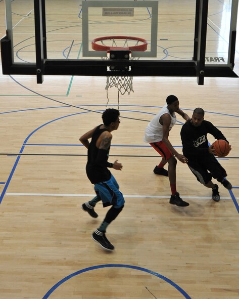 Contestants play during the 86th Airlift Wing African-American History Month Committee’s 21-point Co-Ed Basketball Competition at Ramstein, Germany, Feb. 14, 2015. All participants received a free T-shirt, draw-string gym bag, mini basketball and a pre-paid phone card for attending. (U.S. Air Force photo/A1C Tryphena Mayhugh)