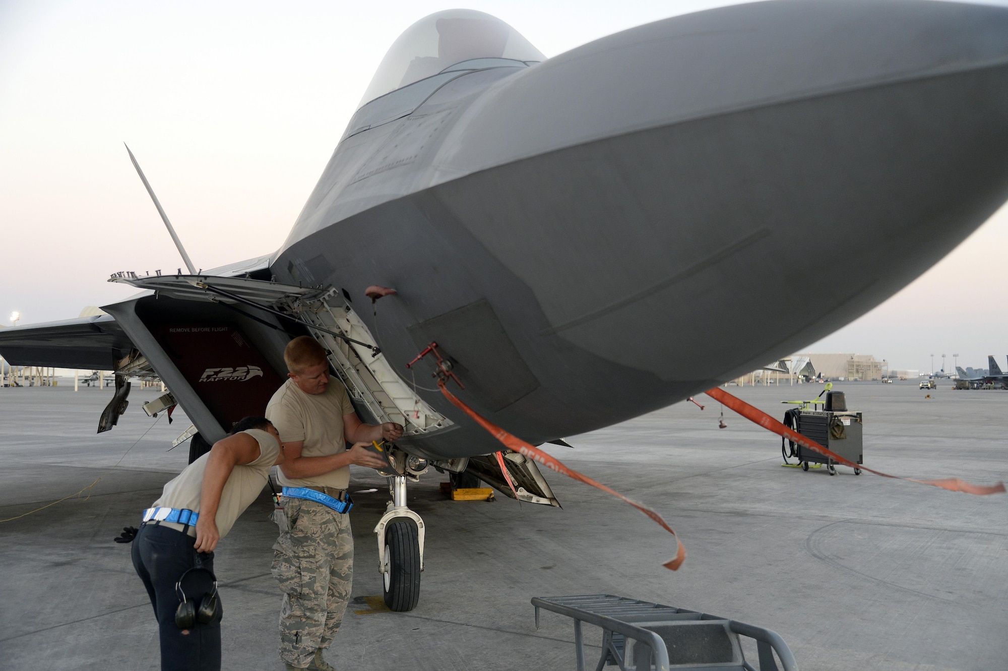 Staff Sgt. James, avionics craftsman, right, and Senior Airman Dakota, launch assist, troubleshoots a communications, navigation and identification system on an F-22 Raptor at an undisclosed location in Southwest Asia Jan. 26, 2015. The F-22 Raptor is the first aircraft to use integrated avionics, where the radar, weapons management system and electronic warfare system work as one, giving the pilot unprecedented situational awareness. James is currently deployed from Tyndall Air Force Base, Fla., and is a native of Frackville, Pa. Dakota is currently deployed from Tyndall AFB, Fla., and is a native of El Paso, Texas. (U.S. Air Force/Tech. Sgt. Marie Brown) 