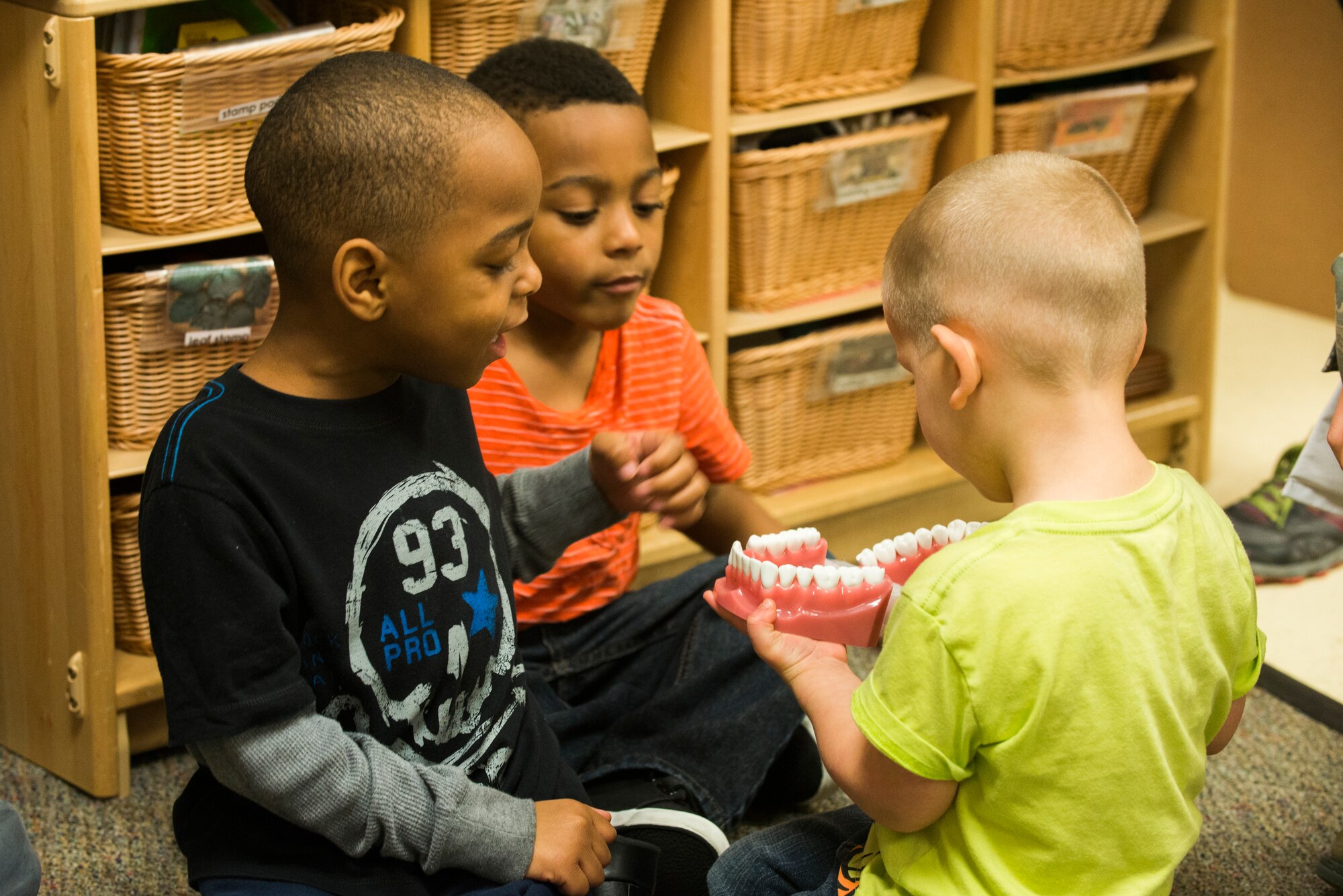 Marcellus Coley, left, Travon Caul, middle, and Tyler Poppineau view a teeth display during a demonstration at the Child Development Center Feb. 10, 2015, at Moody Air Force Base, Ga. To keep children’s teeth healthy during growth, the dental clinic advises parents to begin teeth cleaning at age 1. (U.S. Air Force photo by Airman 1st Class Dillian Bamman/Released)
