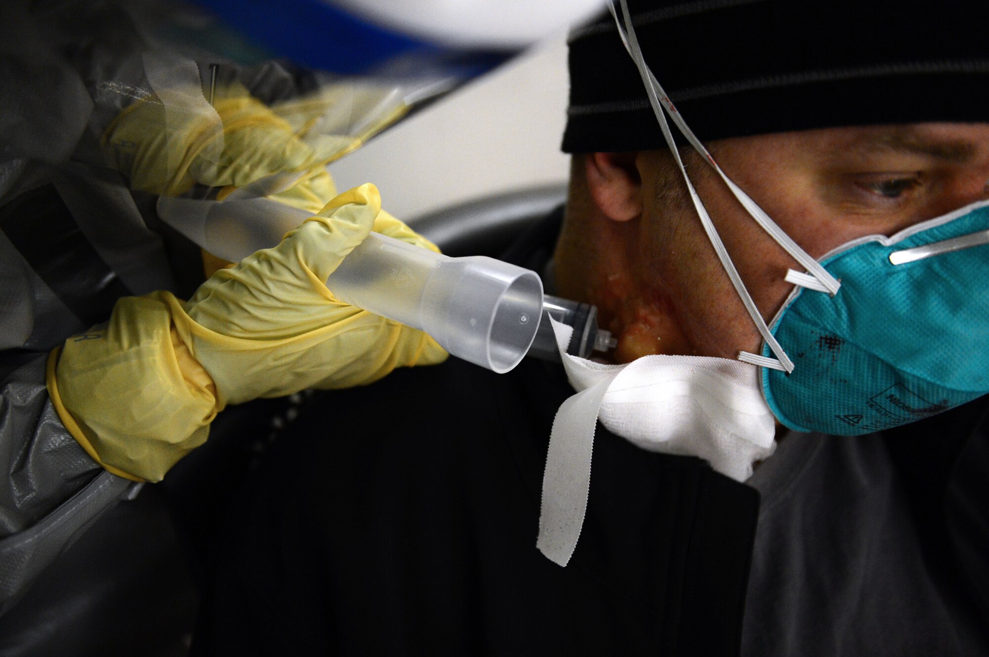 Capt. Erica Middleton, 48th Medical Group emergency room services nurse, biopsies the enlarged lymph node on the neck of Master Sgt. Jay Patterson, 48th MDG operating room flight chief for testing as a part of the disease containment plan exercise at Royal Air Force Lakenheath, England, Feb. 10, 2015. The DCP exercise evaluated the 48th Fighter Wing’s ability to respond to and contain a contagious disease outbreak amongst the base population to ensure the 48th FW is Forward, Ready, Now. (U.S. Air Force photo by Airman 1st Class Erin R. Babis)