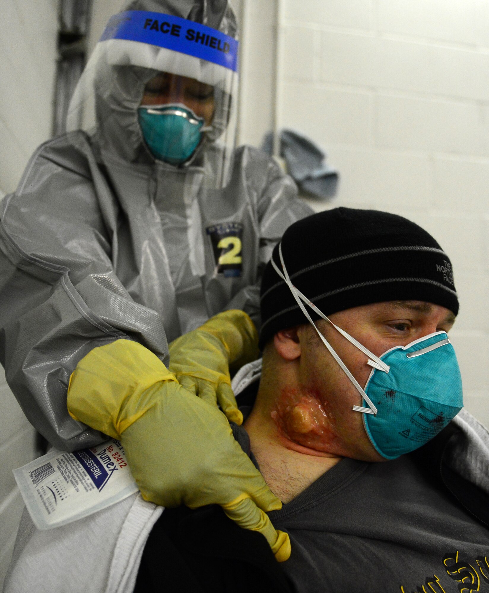 Maj. Terri Jennings, 48th Medical Group emergency services nurse, treats simulated pneumonic plague symptoms on the neck of Master Sgt. Jay Patterson, 48th MDG operating room flight chief, as part of a disease containment plan exercise at Royal Air Force Lakenheath, England, Feb. 10, 2015. This was the first time RAF Lakenheath executed a practical DCP exercise which evaluates the 48th Fighter Wing’s ability to respond to and contain a contagious disease outbreak. (U.S. Air Force photo by Airman 1st Class Erin R. Babis)