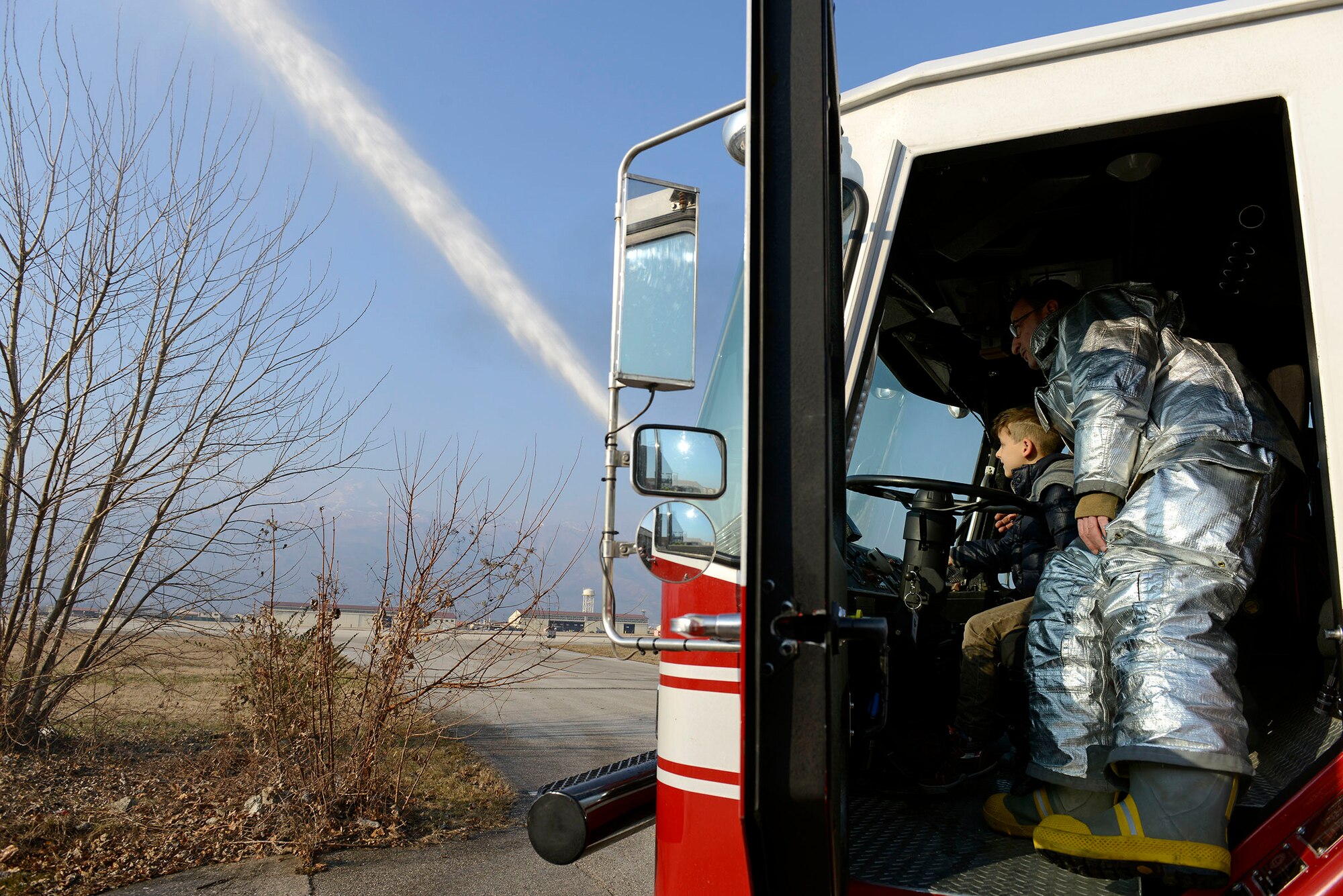 A child from the pediatric oncology department at the Aviano National Cancer Institute in Aviano, Italy, operates a water turret on a 31st Civil Engineer Squadron fire truck at Aviano Air Base, Feb. 12, 2015. The visit provided the children and their families an opportunity to experience something out-of-the ordinary, and take their minds off their current health condition. (U.S. Air Force photo/Airman 1st Class Ryan Conroy)