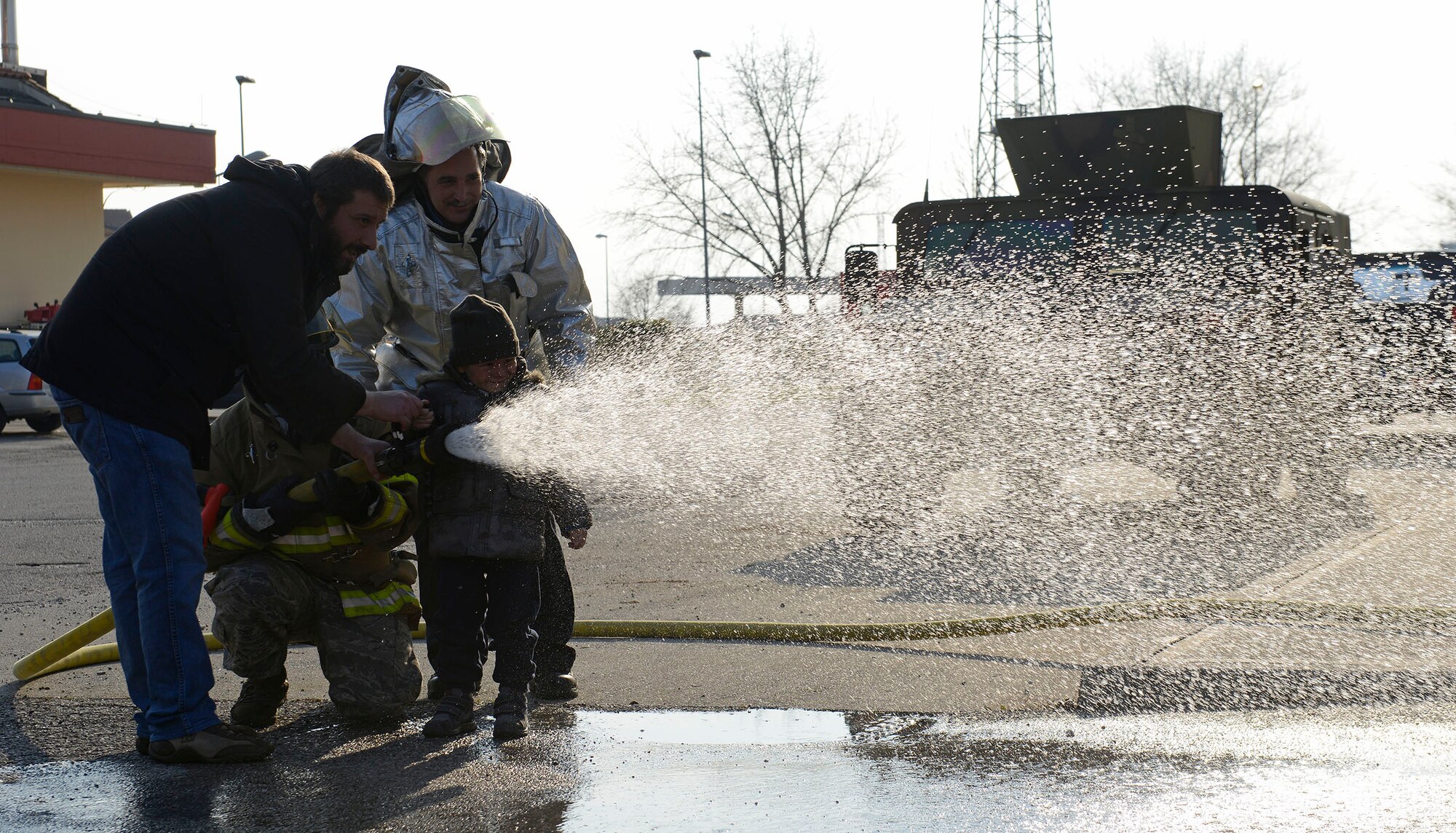 A child from the pediatric oncology department at the Aviano National Cancer Institute in Aviano, Italy, operates a fire hose at the 31st Civil Engineer Squadron fire department at Aviano Air Base, Feb. 12, 2015. Several children, their family and friends, visited the base for a tour where they visited the fire department and got a close-up look at an F-16 Fighting Falcon. (U.S. Air Force photo/Airman 1st Class Ryan Conroy)
