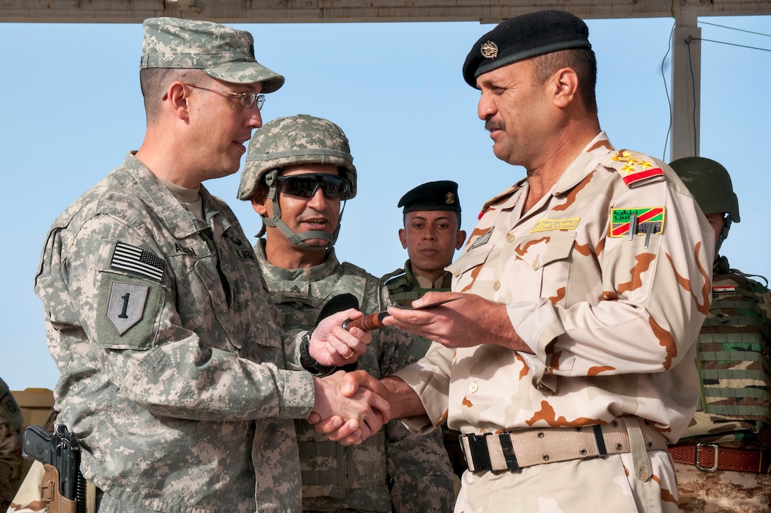 U.S. Army Lt. Col. Scott Allen, left, presents a ceremonial knife to Iraqi army Brig. Gen. Sa’ad during a graduation ceremony on Camp Taji, Iraq, Feb. 13, 2015. Allen is commander of the 1st Infantry Division's 2nd Battalion, 34th Armor Regiment, 1st Armored Brigade Combat Team.
