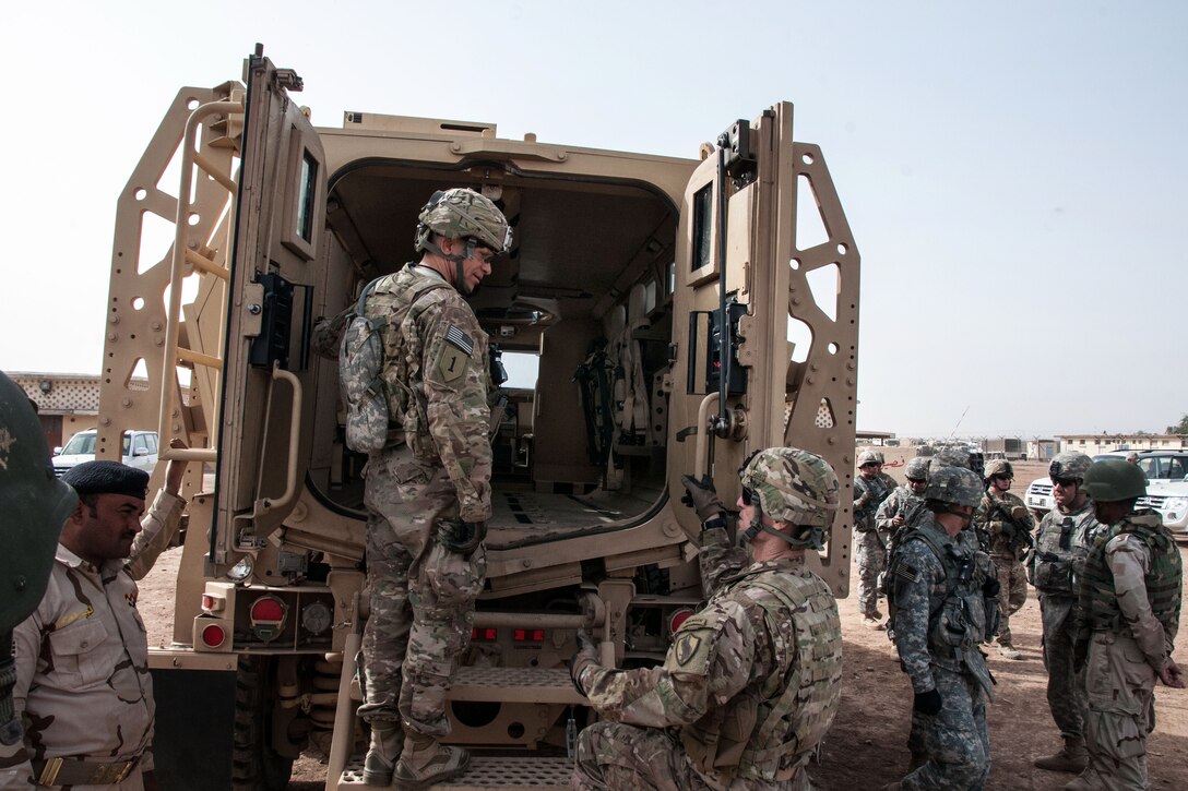 U.S. Army Command Sgt. Maj. Michael A. Grinston, center, climbs aboard a mine-resistant, ambush-protected vehicle during vehicle training on Al Asad Air Base, Iraq, Feb. 11, 2015. Grinston is the senior enlisted advisor to the Combined Joint Forces Land Component Command - Iraq.