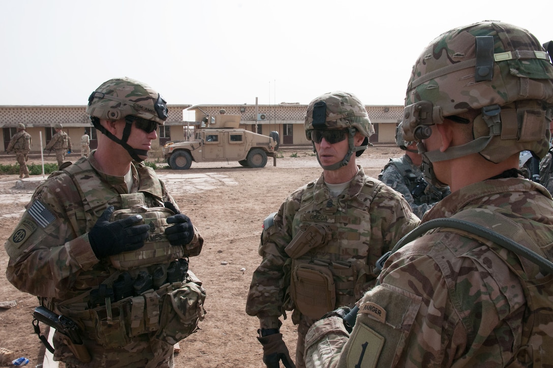 U.S. Army Command Sgt. Maj. Michael J. Ames, left, listens to a comment ...