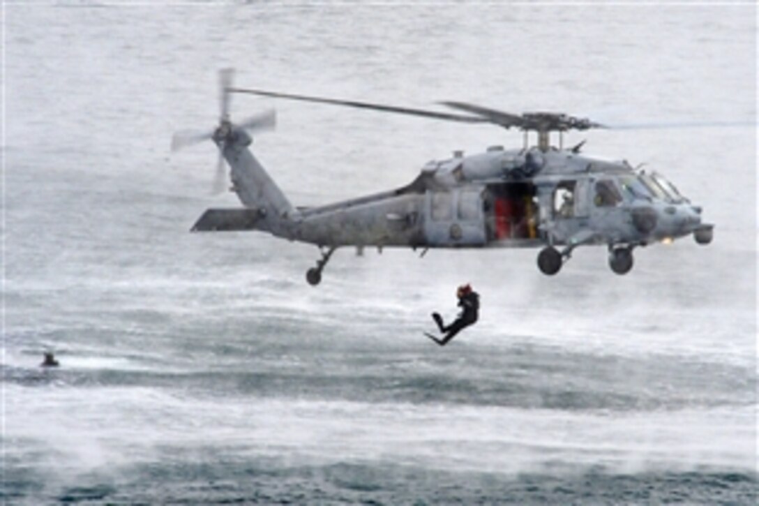 Search and rescue swimmers assigned to Helicopter Sea Combat Squadron 4 train from an MH-60S Seahawk helicopter during qualifications in San Diego, Jan. 28, 2015. 