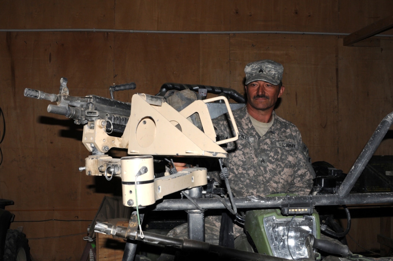 U.S. Army Sgt. Theodore Sweet, a welder with Company E, 3rd Battalion of the 172nd Infantry Regiment stands behind a mount for an M240B that he created for an all-terrain vehicle, May 18. The mount was used during a fire fight by special forces Soldiers recently. Sweet, of Burke, N.Y., welds this and many inventions from scrap metal that would normally be made by industrial machinery at his metal shop on Forward Operating Base Lightning.