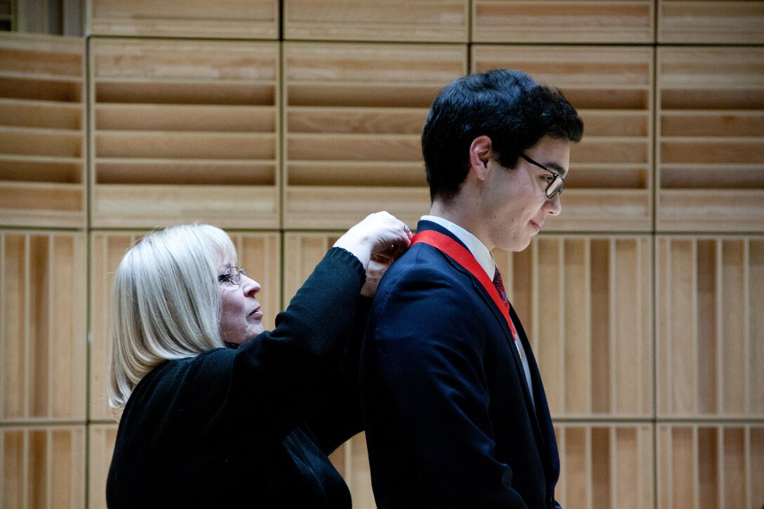 Susan Hodges of the Marine Corps Heritage Foundation congratulates winner and saxophone player Chad Lilley with a medal and $2500. (U.S. Marine Corps photo by Staff Sgt. Rachel Ghadiali/released) 