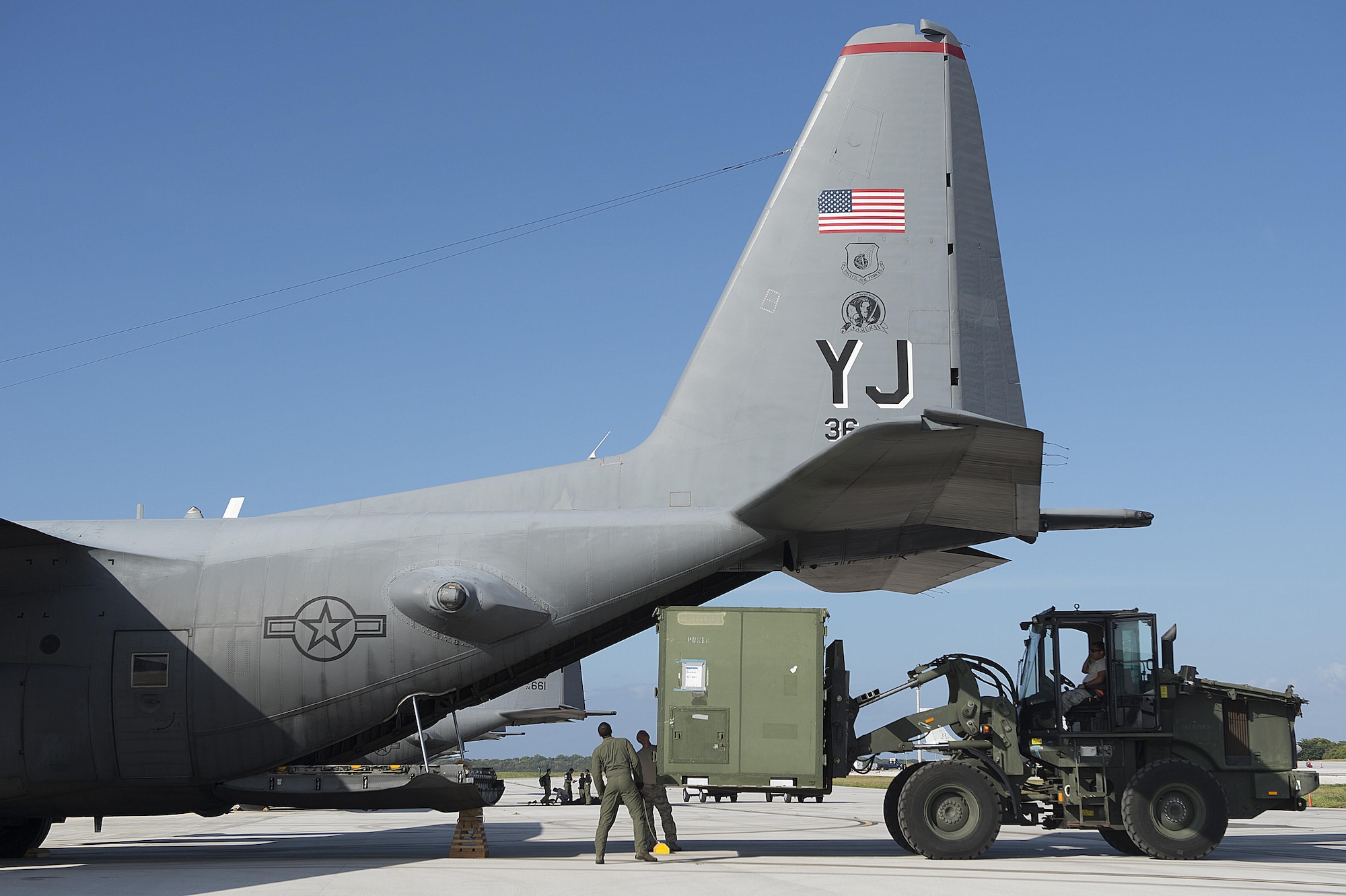 Airmen from the 36th Contingency Response Group and the 36th Airlift Squadron load containers onto a C-130 Hercules during a humanitarian assistance and disaster relief training event Feb. 15, 2015, during exercise Cope North 15 at Anderson Air Force Base, Guam. The exercise enhances humanitarian assistance and disaster relief crisis response capabilities between six nations and lays the foundation for regional cooperation expansion during real-world contingencies in the Asia-Pacific Region. (U.S. Air Force photo/Tech. Sgt. Jason Robertson)