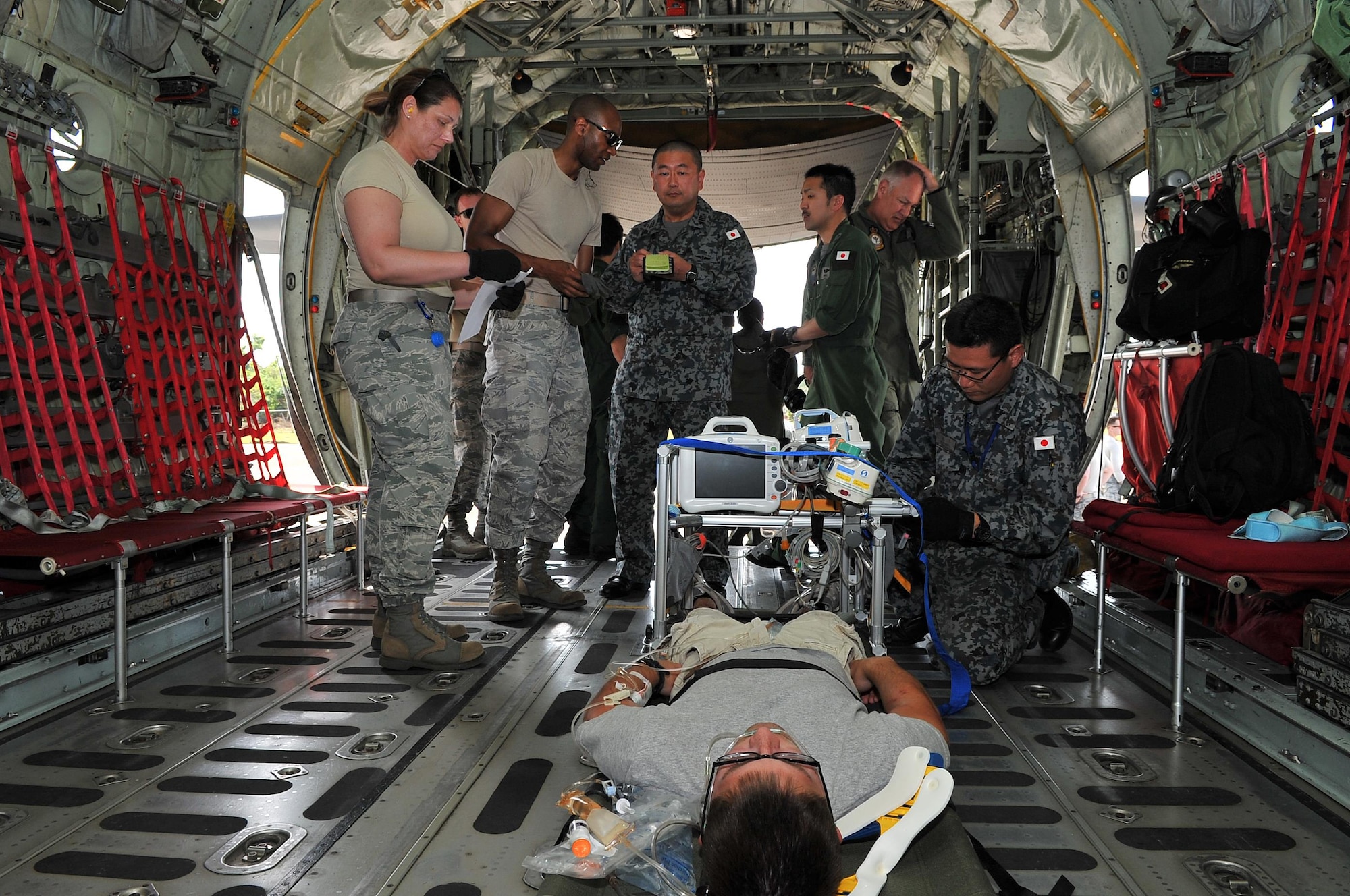 Airmen transfer a simulated critical care patient to a Japan Air Self-Defense Force aeromedical evacuation team Feb. 16, 2015, during exercise Cope North 15 at Sinapalo, Rota. The exercise enhances humanitarian assistance and disaster relief crisis response capabilities between six nations and lays the foundation for regional cooperation expansion during real-world contingencies in the Asia-Pacific Region. (U.S. Air Force photo/Tech. Sgt. Jason Robertson)