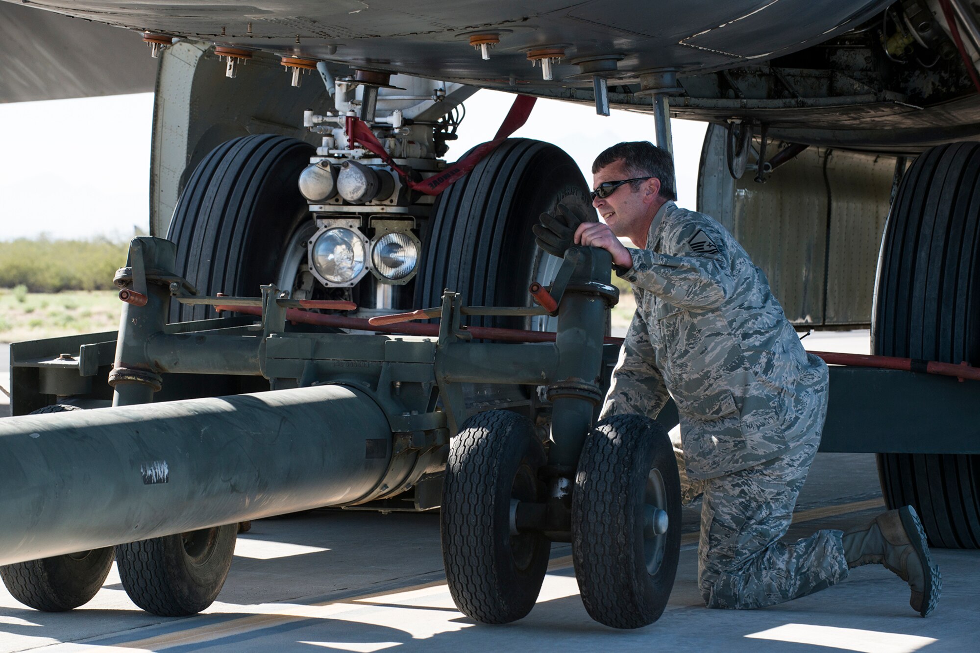 U.S. Air Force Master Sgt. Steve Vance, 307th Aircraft Maintenance Squadron crew chief, disconnects a tow bar from a B-52H Stratofortress after towing it to a parking spot on the flight line at Davis-Monthan (DM) Air Force Base, Ariz., Feb. 11, 2015. The aircraft was decommissioned in 2008 and sent to the "Boneyard" at the 309th Aerospace Maintenance and Regeneration Group at DM, but is now being restored and is expected to return to active service in 2016. (U.S. Air Force photo by Master Sgt. Greg Steele/Released)