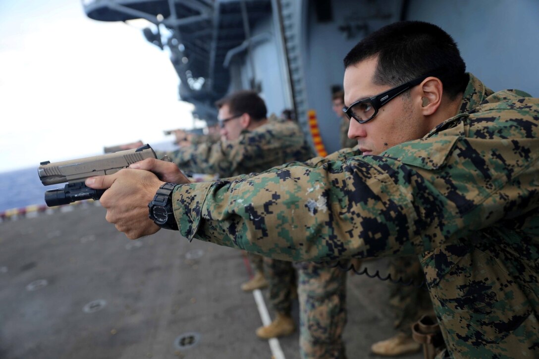 Sgt. Raymond Figueroa, a reconnaissance Marine with the Force Reconnaissance Detachment, 11th Marine Expeditionary Unit, sights in on his target during a pistol qualification aboard the amphibious assault ship USS Makin Island (LHD 8), Feb. 10. Embarked aboard the three ships of the Makin Island Amphibious Ready Group, the 11th MEU has provided a flexible, sea-based, crisis response force to regional commanders throughout its seven-month Western Pacific deployment. (U.S. Marine Corps photos by Cpl. Demetrius Morgan/Released)   
