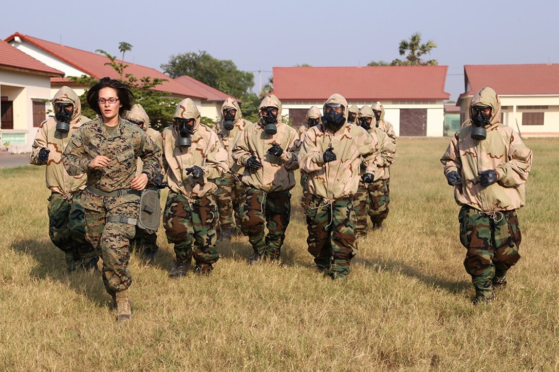 Cpl. Elizabeth Higgins, a Chemical Biological Radiological Nuclear (CBRN) Assessment and Consequence Management (ACM) team member with the 11th Marine Expeditionary Unit, leads members of National Counter Terrorism Special Forces (NCTSF) of Cambodia dressed in Mission Oriented Protective Posture (MOPP) suits, during a conditioning foot movement en route to a confidence exercise chamber as part of a week-long course teaching the Cambodian service members ACM team in order to further improve their capability to deal with CBRN and Weapons of Mass Destruction (WMD) threats in Phnom Penh, Cambodia, Feb. 10. Now in the last month of a seven-month WESTPAC deployment, the 11th Marine Expeditionary Unit has provided a flexible, sea-based crisis response force to the commanders of U.S. Central Command, 5th Fleet, and 7th Fleet. (U.S. Marine Corps photo by Cpl. Laura Y. Raga/Released)