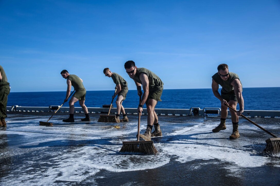 Marines with Marine Medium Tiltrotor Squadron 163 (Reinforced), 11th Marine Expeditionary Unit, scrub the flight deck of the amphibious assault ship USS Makin Island (LHD 8), Feb. 8. The 11th MEU and Makin Island Amphibious Ready Group are deployed in support of maritime and theater security operations in the U.S. 7th fleet area of responsibility. (U.S. Marine Corps photo by Cpl. Evan R. White/Released)