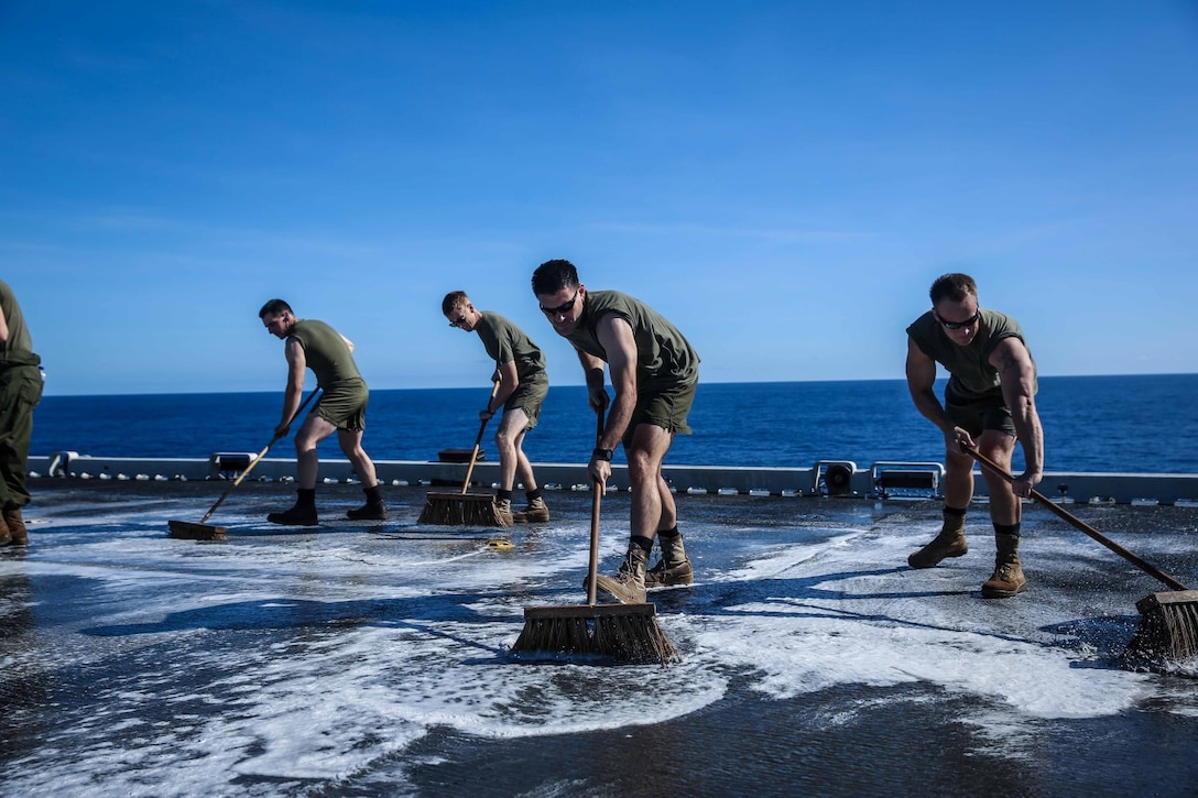 Marines with Marine Medium Tiltrotor Squadron 163 (Reinforced), 11th Marine Expeditionary Unit, scrub the flight deck of the amphibious assault ship USS Makin Island (LHD 8), Feb. 8. The 11th MEU and Makin Island Amphibious Ready Group are deployed in support of maritime and theater security operations in the U.S. 7th fleet area of responsibility. (U.S. Marine Corps photo by Cpl. Evan R. White/Released)