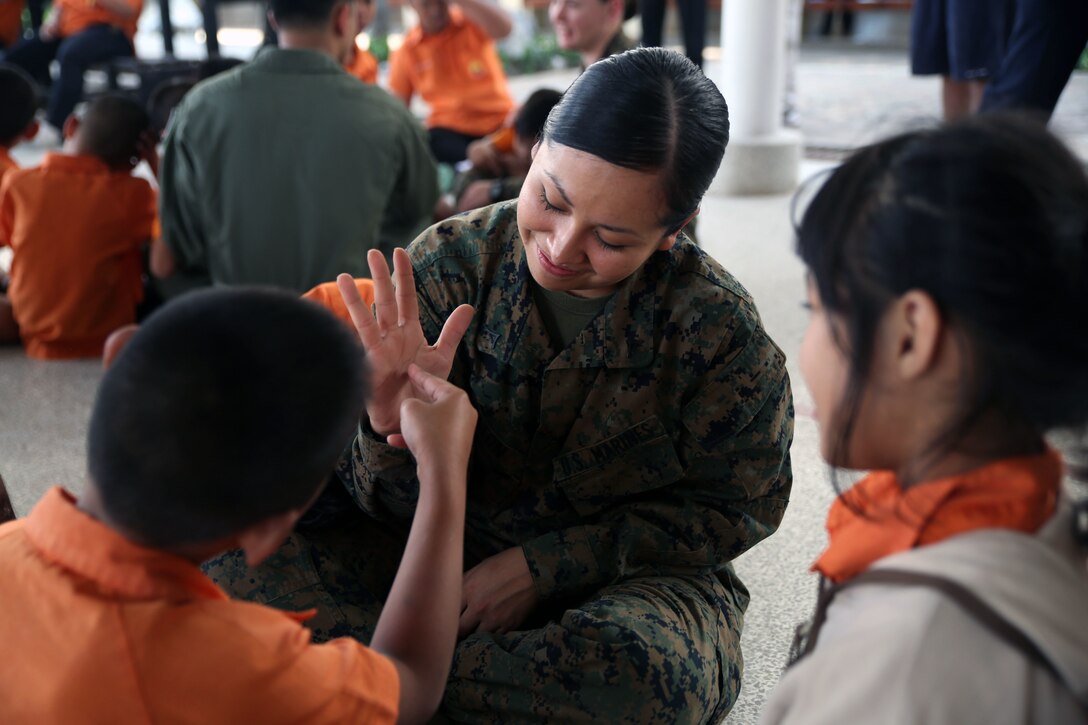 Lance Cpl. Sherry L. Eaton sits with children from Nakhon Ratchasima Panyonnookun School during a community outreach event February 12. The school provides education for 295 children with disabilities such as autism, Down syndrome, hearing loss, and attention deficit hyperactivity disorder. Marines with 1st Marine Aircraft Wing and members of the Royal Thai Air Force volunteered at the school during Exercise Cobra Gold 2015 to spend time in the community. Eaton is an aviation technician with Marine All Weather Fighter Attack Squadron 533, attached to Marine Aircraft Group 12, 1st Marine Aircraft Wing, III Marine Expeditionary Force, under the Unit Deployment Program.  For more information on Exercise Cobra Gold, please visit the official Facebook page at http://www.facebook.com/ExerciseCobraGold.