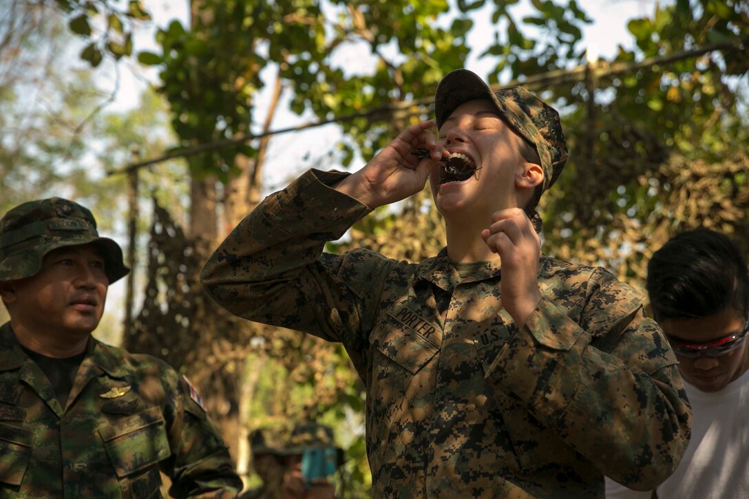 Cpl. Kyleigh M. Porter, from Montross, Va., eats a scorpion Feb. 8 in Ban Chan Krem, Thailand, during exercise Cobra Gold 2015. The Royal Thai Marines demonstrated several jungle survival tactics and asked for U.S. Marine volunteers to participate. Porter is a radio operator with Marine Air Support Squadron 2, Marine Air Control Group 18, 1st Marine Aircraft Wing, III Marine Expeditionary Force. 