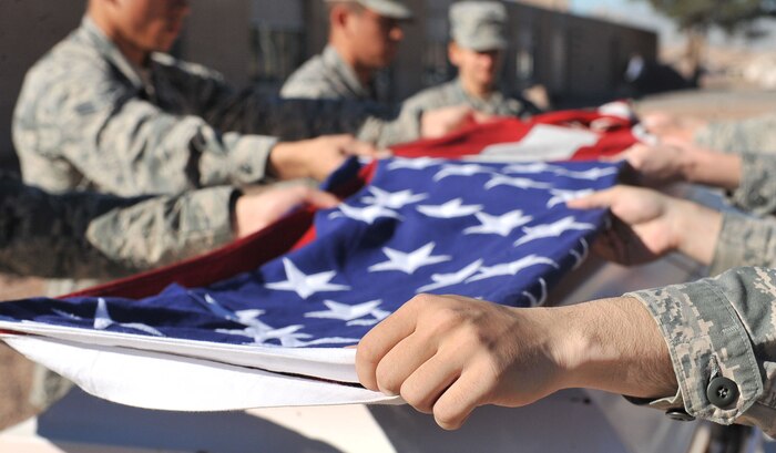 Members of the Nellis Air Force Base Honor Guard practice a six-person flag fold during a training session at Nellis AFB, Feb. 17, 2015. The flag is folded in two parts reminding citizens of two parts of life: birth and death and life here and hereafter. (U.S. Air Force photo by Airman 1st Class Rachel Loftis)