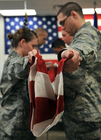Members of the Nellis Air Force Base Honor Guard practices a six-person flag fold during a training session at Nellis AFB, Feb. 17, 2015. There are two different flag folding sequences utilized by the honor guard, the two-person and the six-person flag fold. (U.S. Air Force photo by Airman 1st Class Rachel Loftis)