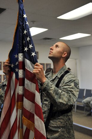 Staff Sgt. Nicholas Cocco, Nellis Air Force Base honor guardsman, presents the colors during a scheduled practice at Nellis AFB, Nev. Feb. 17, 2015. The color's of the flag represent the following: Courage is derived from the red stripes, freedom is derived from the white stars on the blue field representing a sky free from fire, flack, and oppression and peace is derived from the white stripes representing purity in every form. (U.S. Air Force photo by Airman 1st Class Rachel Loftis)