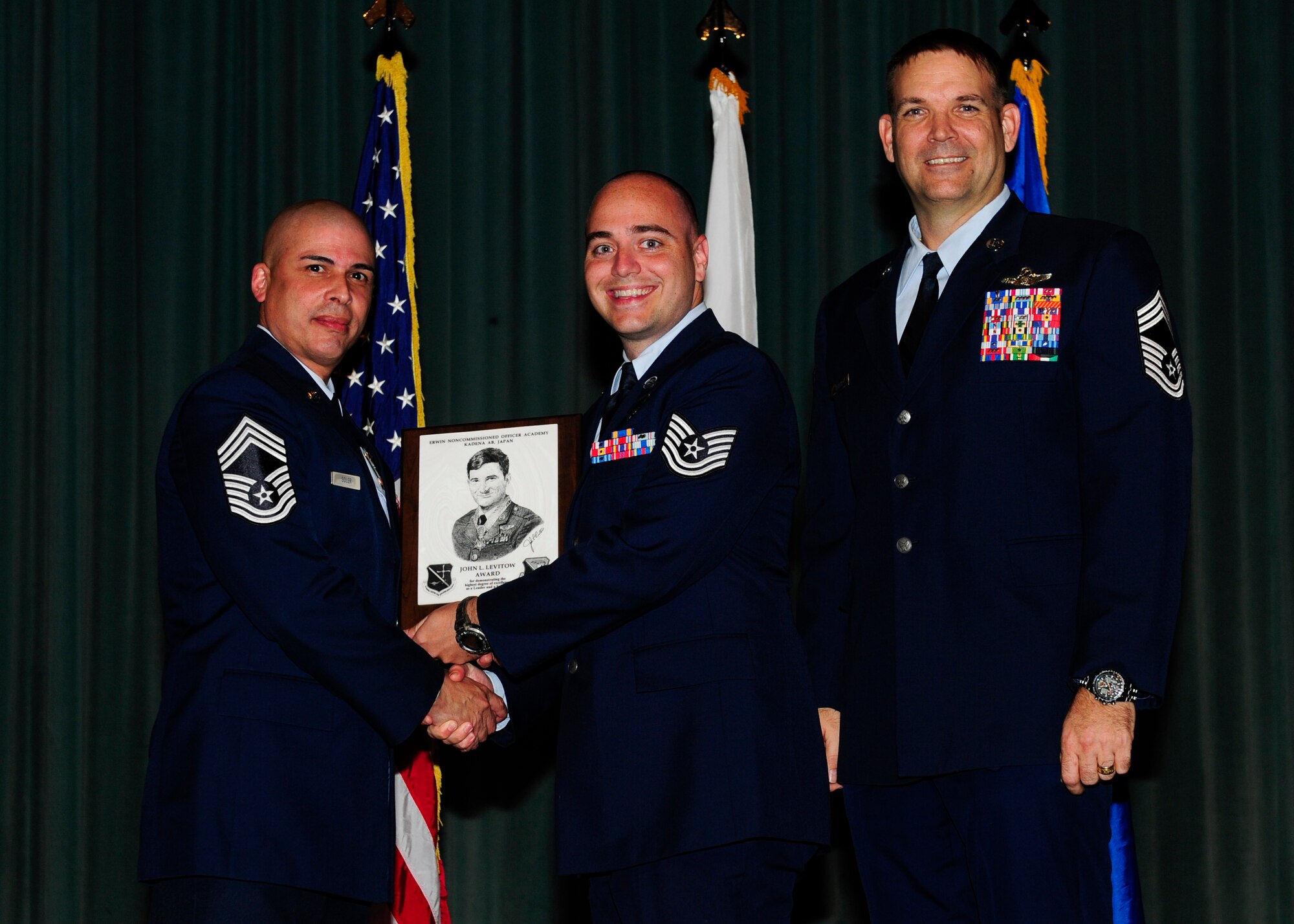 U.S. Air Force Tech. Sgt. Ian Davis, 390th Intelligence Squadron ground systems flight chief, accepts the John L. Levitow Award during the graduation ceremony for NCO Academy Class 15-2 on Kadena Air Base, Japan, Feb. 13, 2014. The John L. Levitow Award is presented to the student who earns the highest average score on evaluations and most embodies the Air Force core values. (U.S. Air Force photo by Airman 1st Class John Linzmeier)