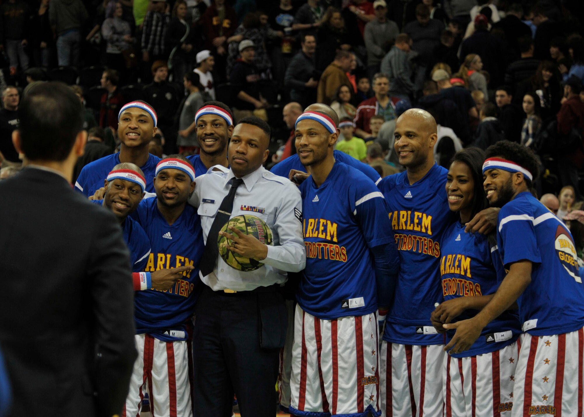 Senior Airman Christopher Atkins, a 92nd Medical Group aerospace medical technician, poses with members of the Harlem Globetrotters after a basketball game between the Globetrotters and the Spokane Generals Feb. 17, 2015, at the Spokane Arena in Spokane, Wash. The Harlem Globetrotters honored Atkins as the Hometown Hero at the beginning of the game and presented him with a camouflage Harlem Globetrotters basketball.  (U.S. Air Force photo/Airman 1st Class Taylor Bourgeous)