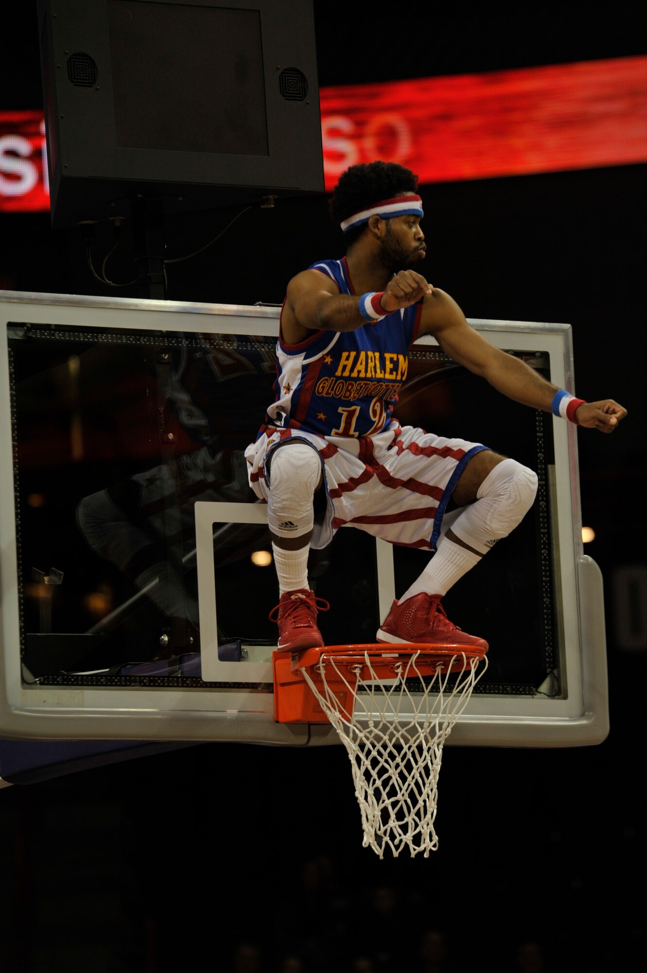 Ant, a Harlem Globetrotters showman, dances on top of the basketball hoop at the Globetrotters game Feb. 17, 2015, at the Spokane Arena in Spokane, Wash. Ant holds the Globetrotter record for making 22 4-pointers in one game. The Globetrotters are the only team who have four special spots designated on the court as 4-pointer shots. (U.S. Air Force photo/Airman 1st Class Taylor Bourgeous)