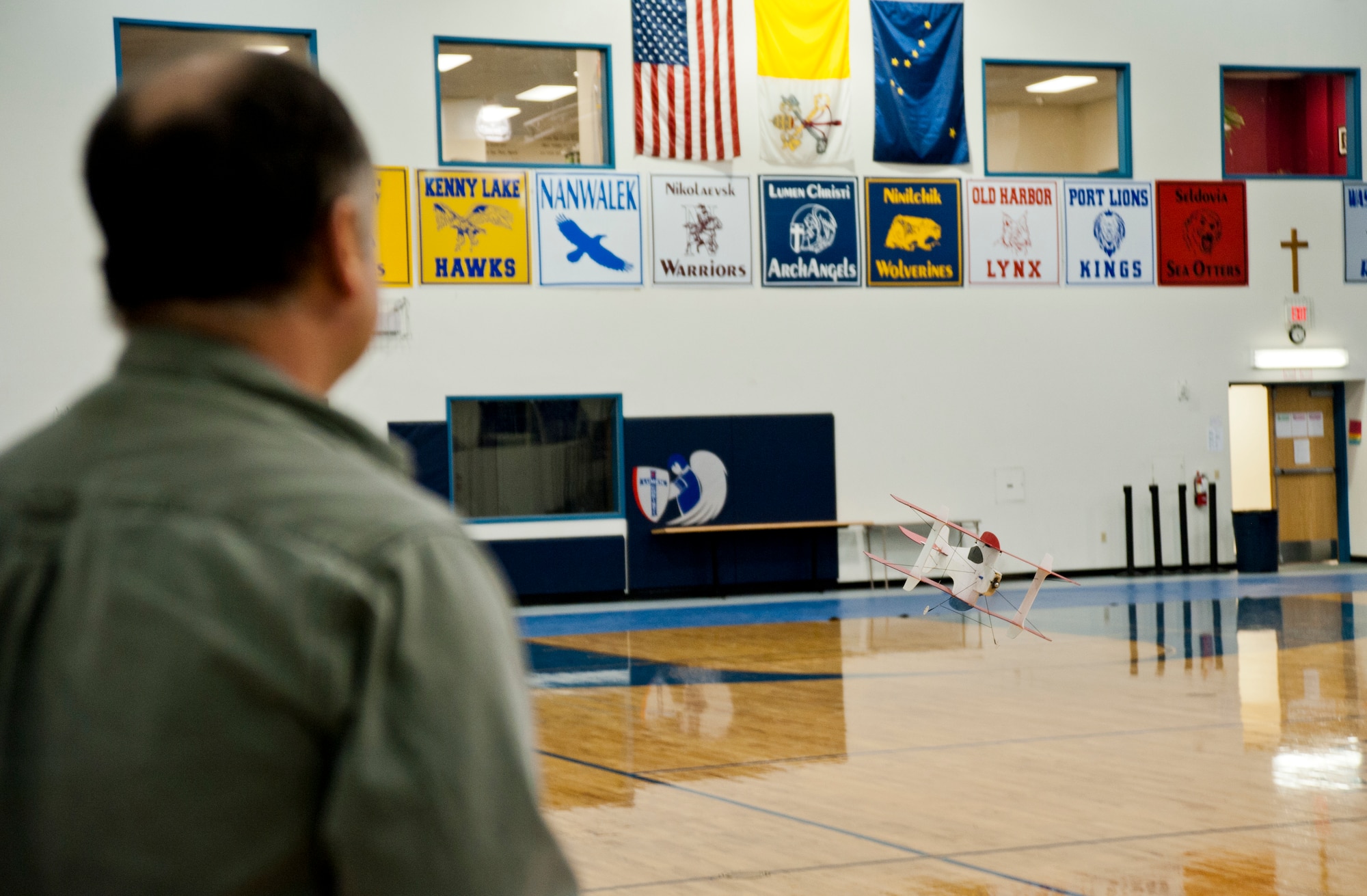 Edward Cunningham, Alaska Radio Control Society member and remotely piloted aircraft pilot, flies his electric-powered aircraft inside the Lumen Christi High School gymnasium, Feb. 15, 2015. On a fully charged battery, the RPA can fly for approximately 10 minutes before needing to be recharged. It takes about 15 to 20 minutes for an electric powered RPA to fully charge before flying. (U.S. Air Force photo/Airman 1st Class Tammie Ramsouer)
