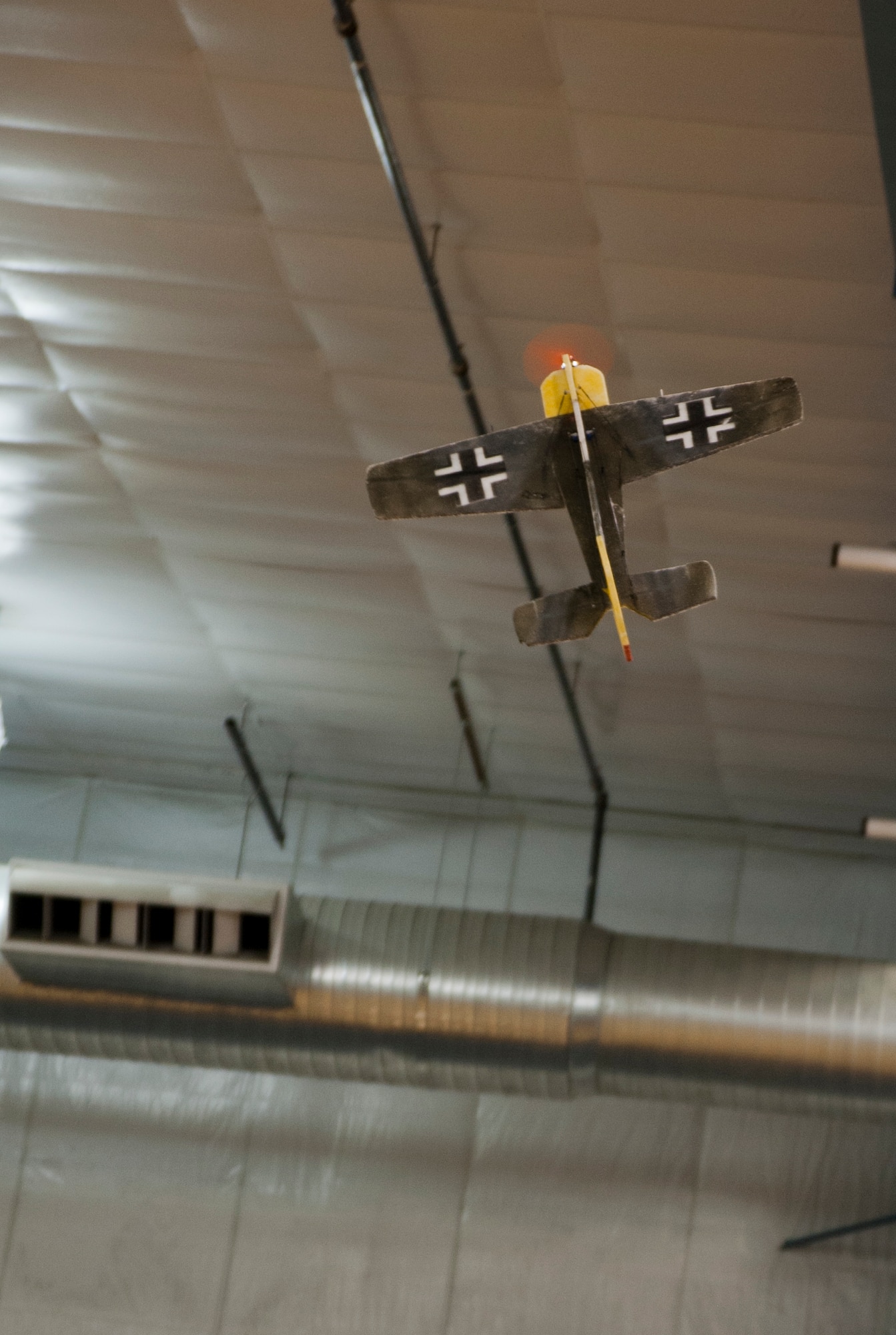 A Messerschmitt ME 109 remotely piloted aircraft flies inside the Lumen Christi High School gymnasium, Feb. 15, 2015. Many RPAs are decorated to look like actual planes that are or have been in use for flying purposes, whether for wartime or peacetime. Members of the Alaska Radio Control Society can fly RPAs indoors only if their aircraft weighs at or less than 16 ounces and is electric powered. (U.S. Air Force photo/Airman 1st Class Tammie Ramsouer)